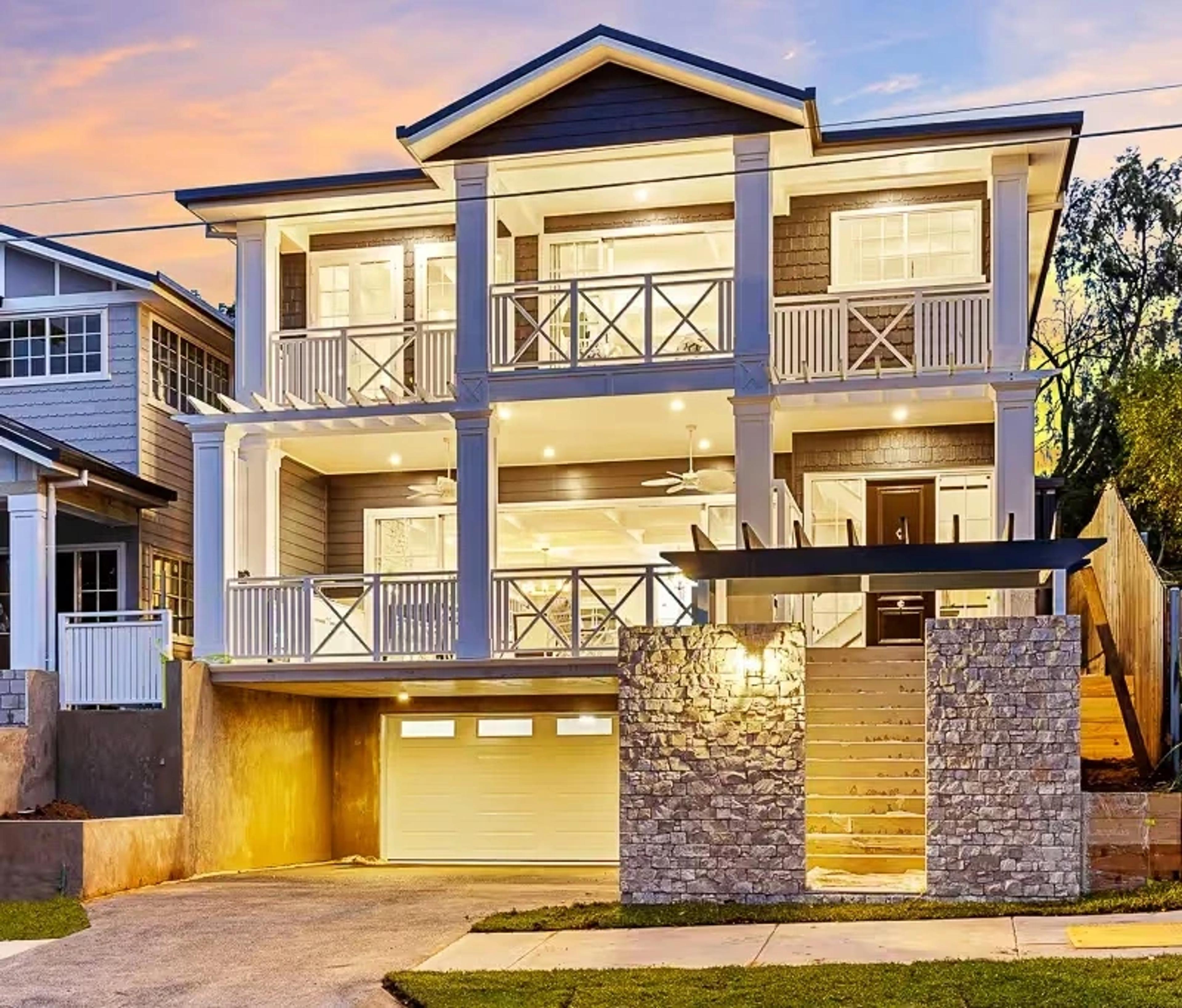 Grey weatherboard home front facade with garage at dusk