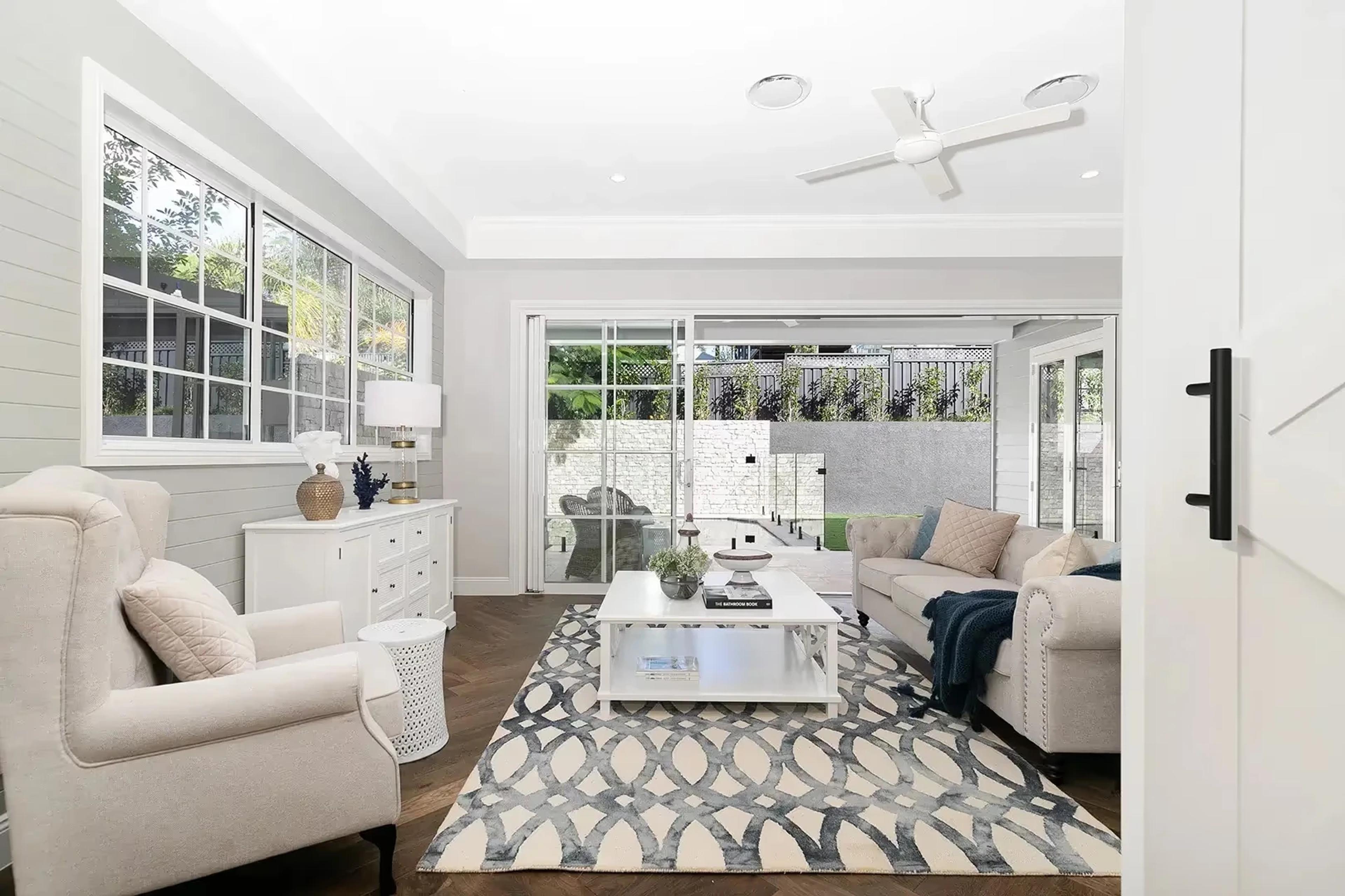 Sitting room with armchair, sofa and sliding doors to courtyard