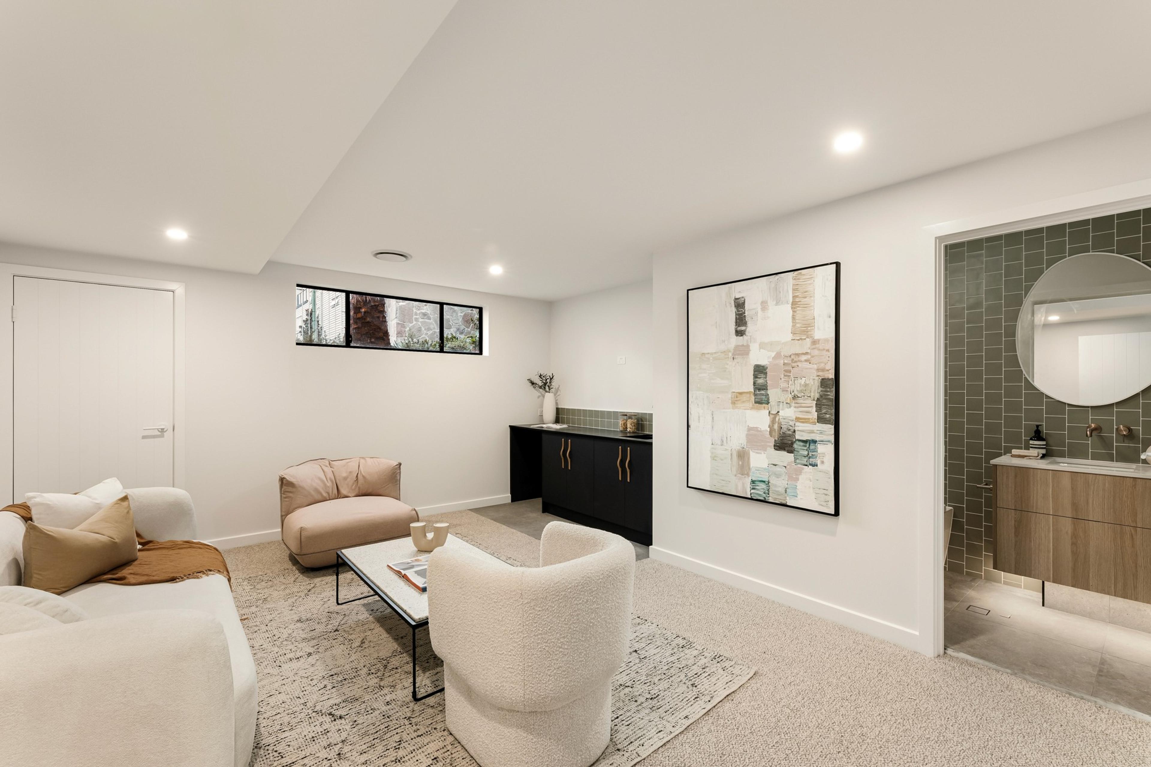 Secondary living space with armchairs and green tiled ensuite beyond
