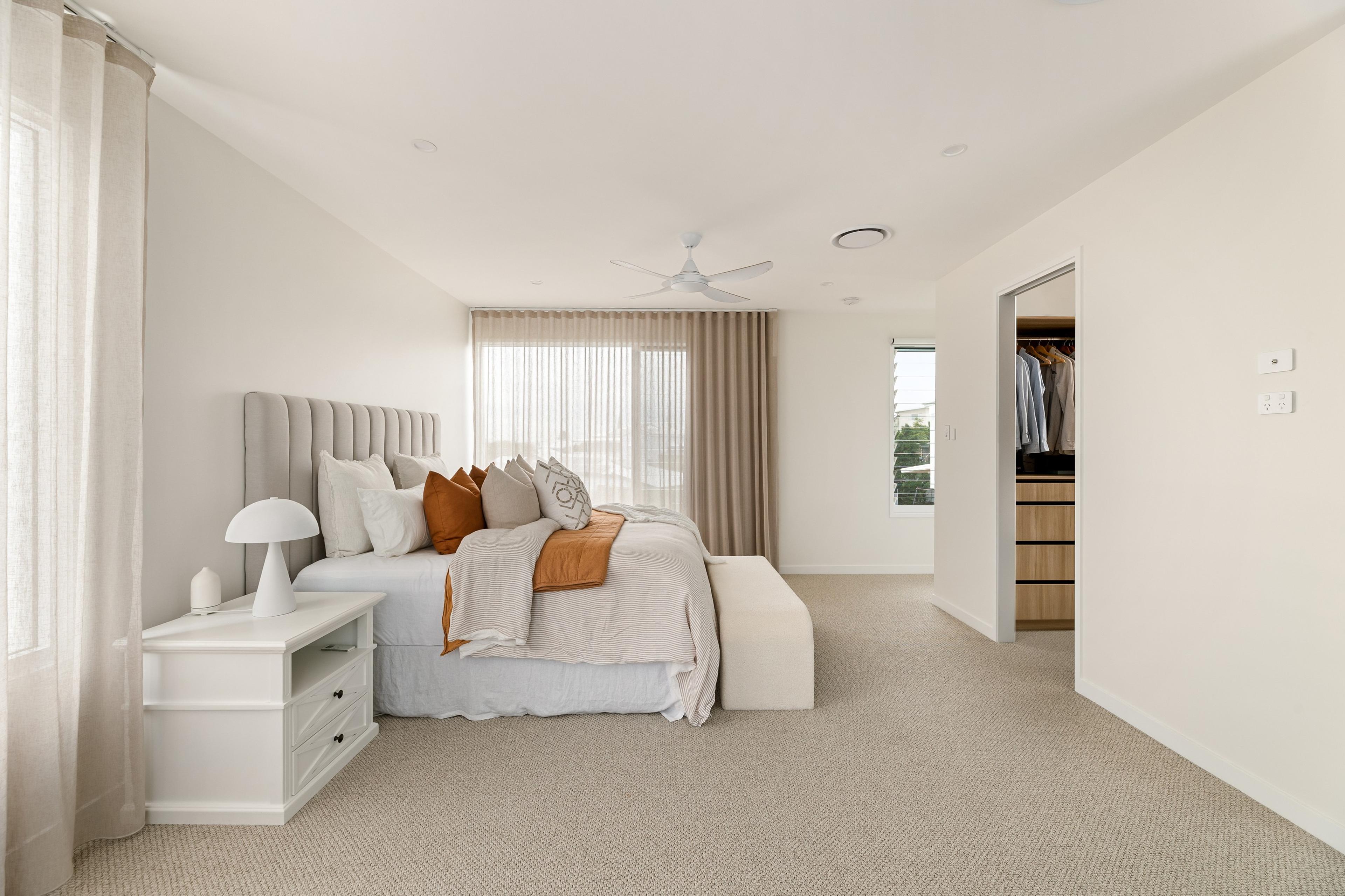 Main bedroom with upholstered bedhead and walk in wardrobe