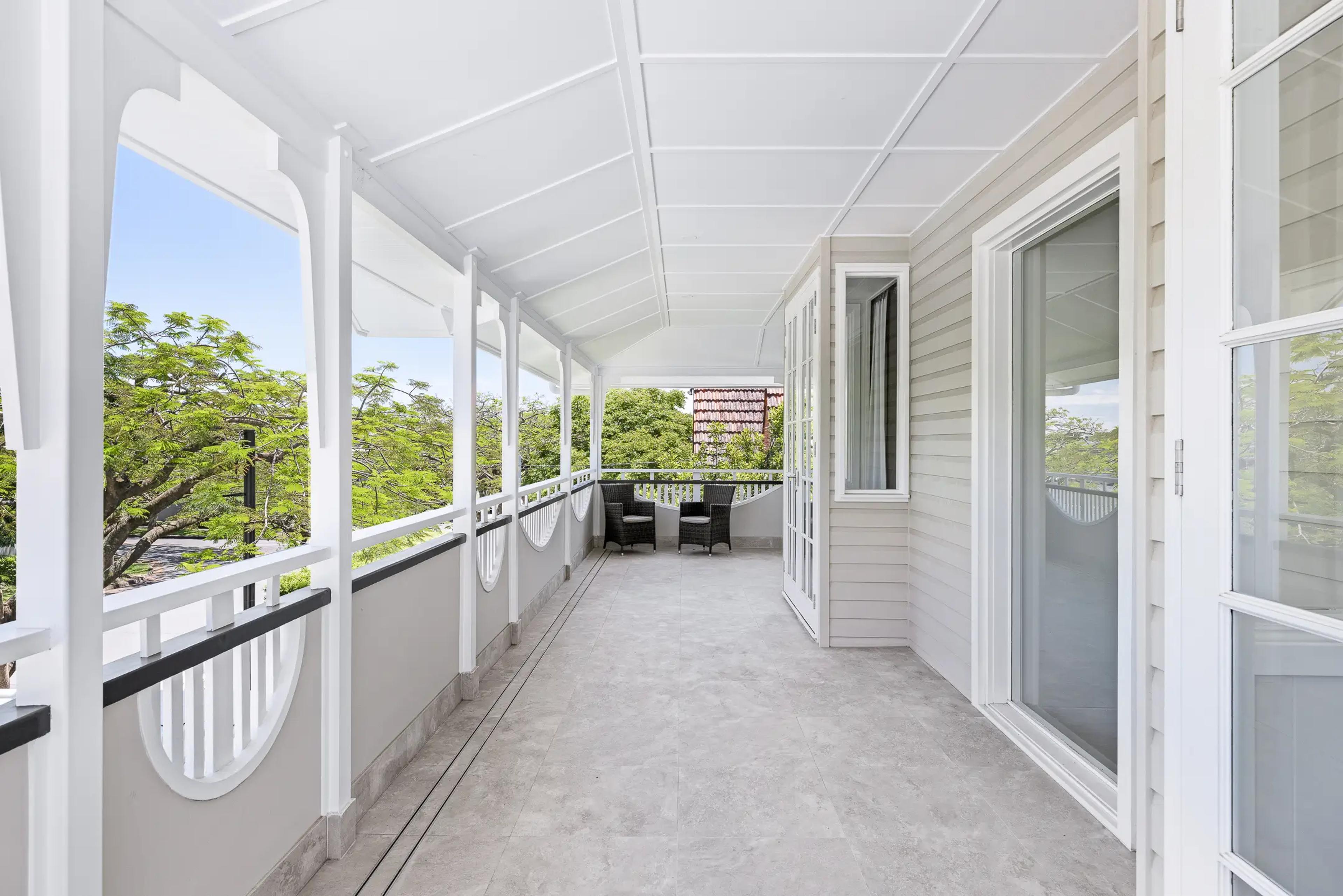 Upstairs verandah with white balustrade and treetop views