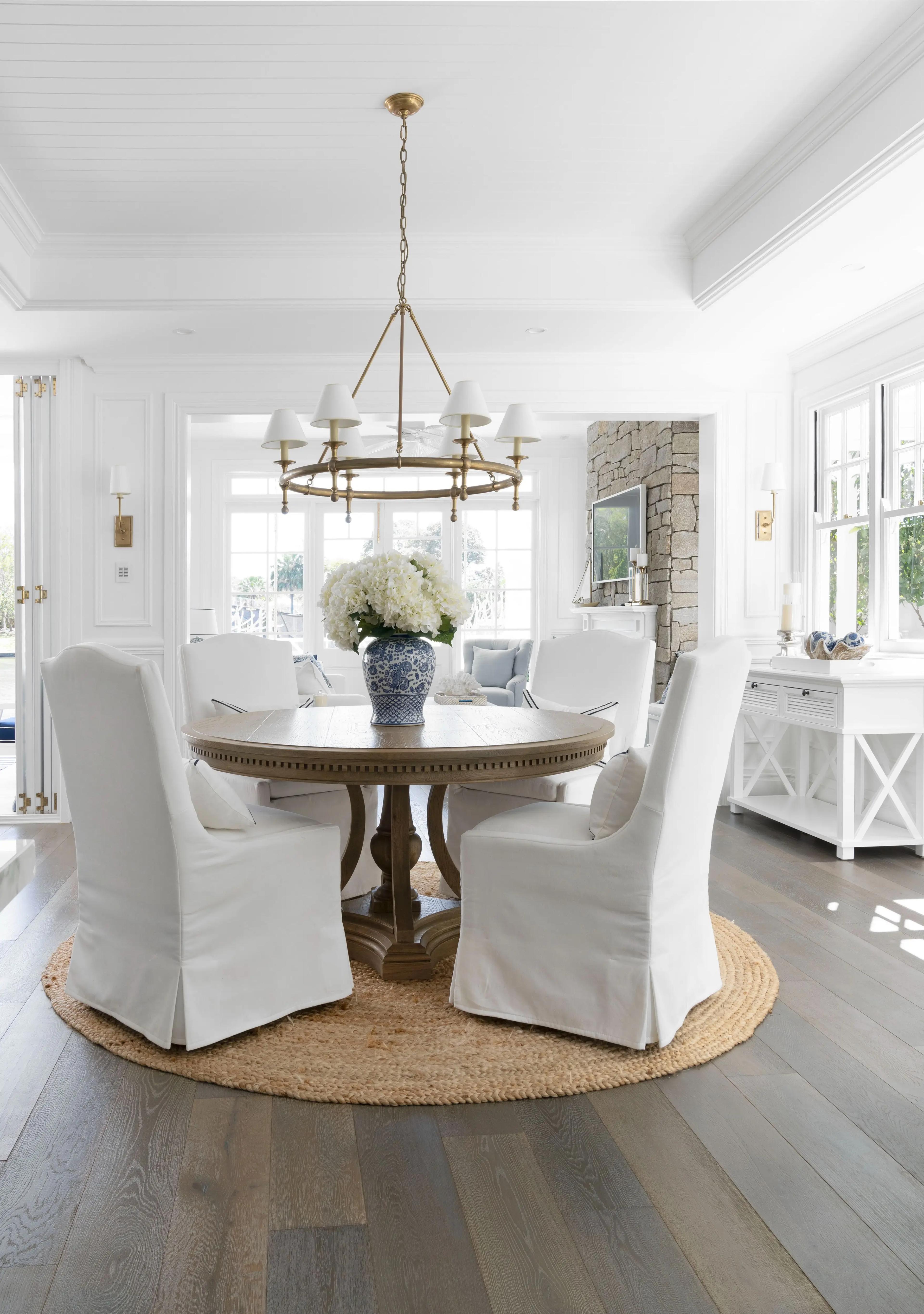 Dining room with round timber table and brass ring chandelier
