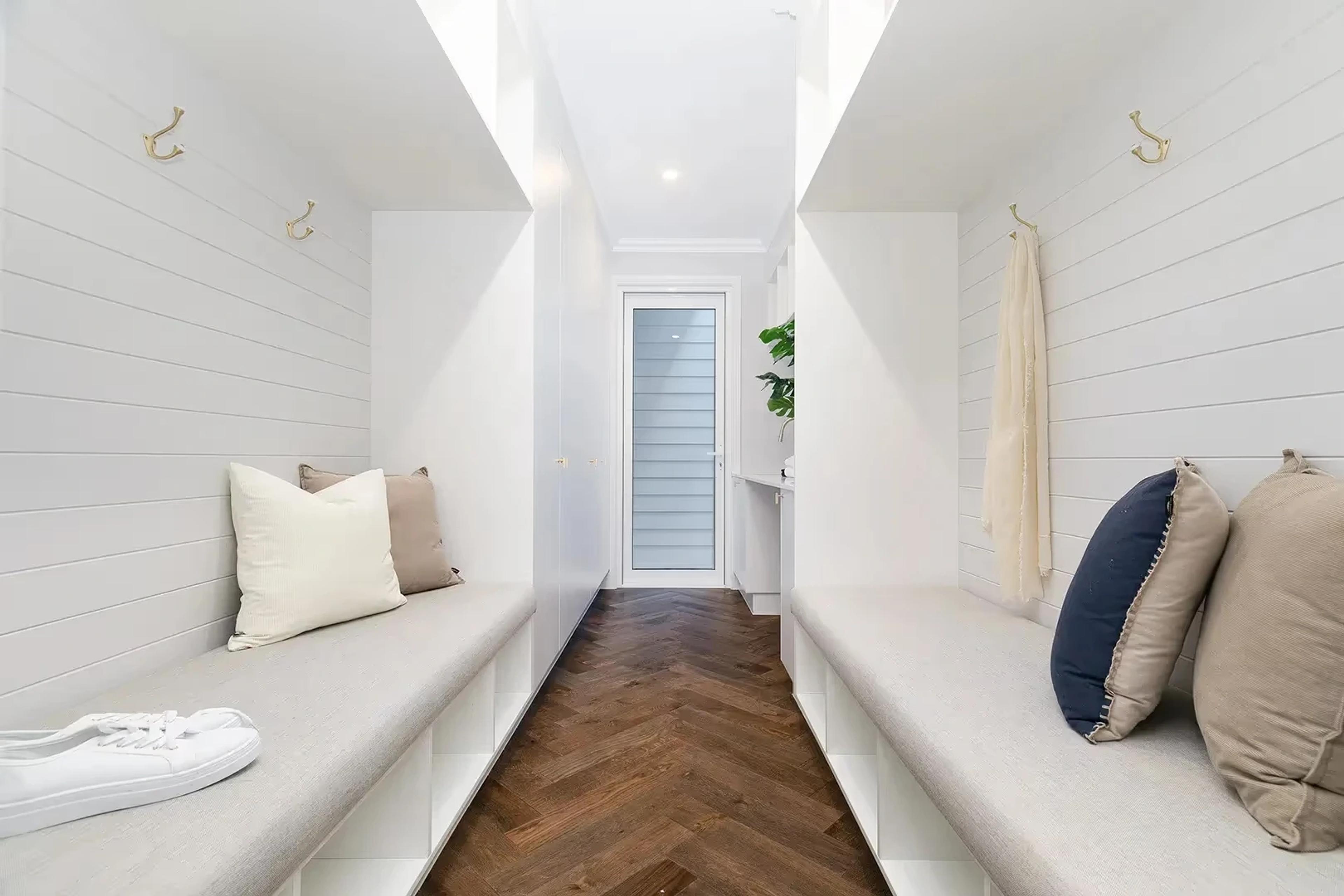 Mudroom hallway with bench seating and coat hooks