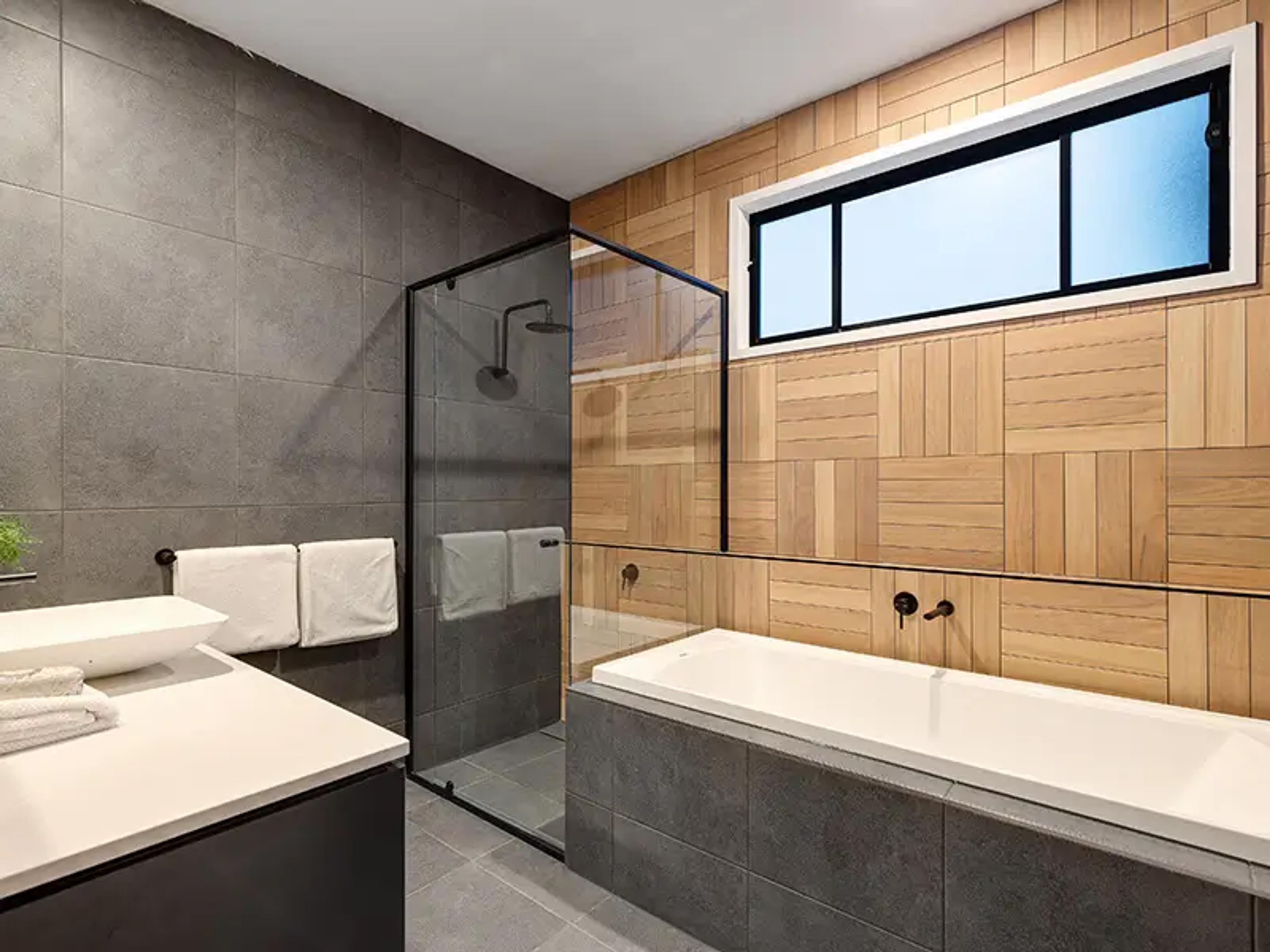 Bathroom with built in bath, shower and timber feature wall