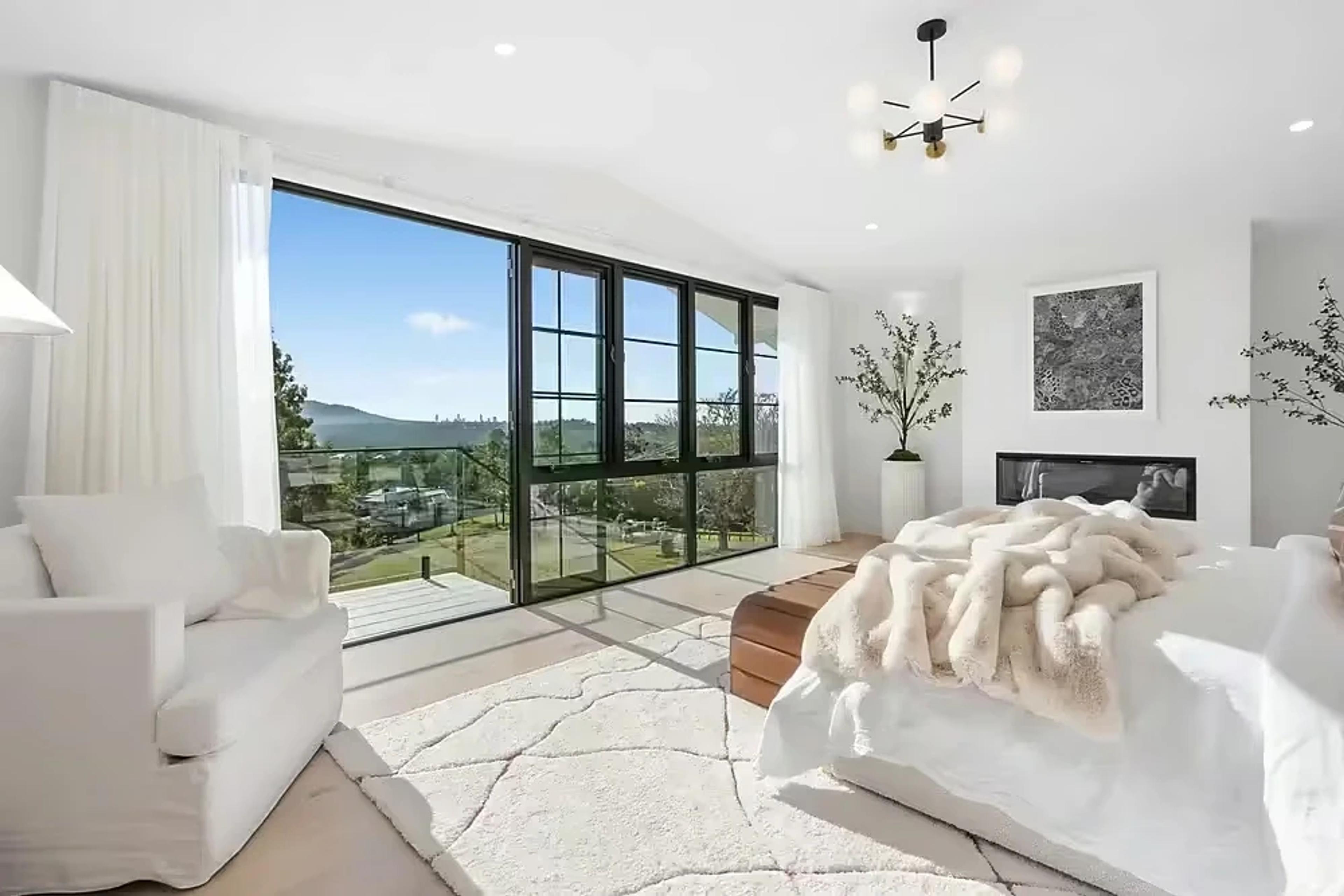 Master bedroom with fireplace and floor-to-ceiling valley views.