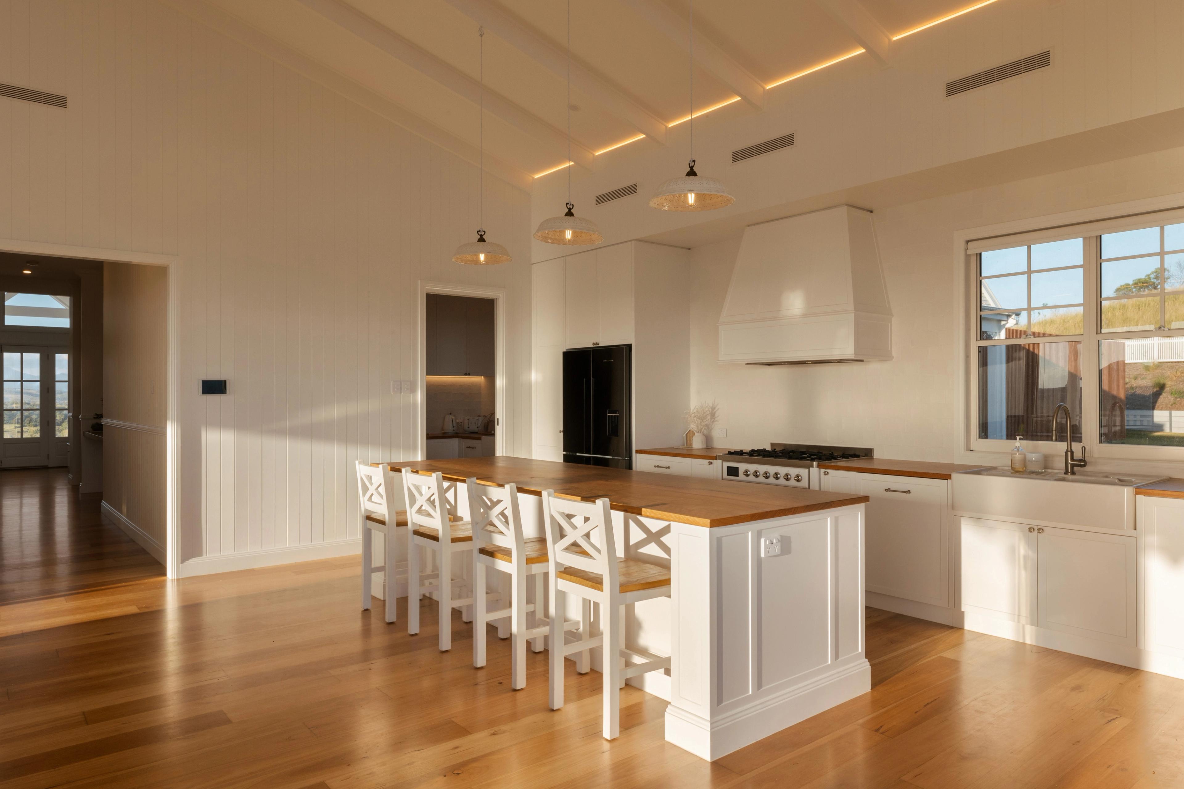 Open kitchen with island bench, range hood and pendant lights