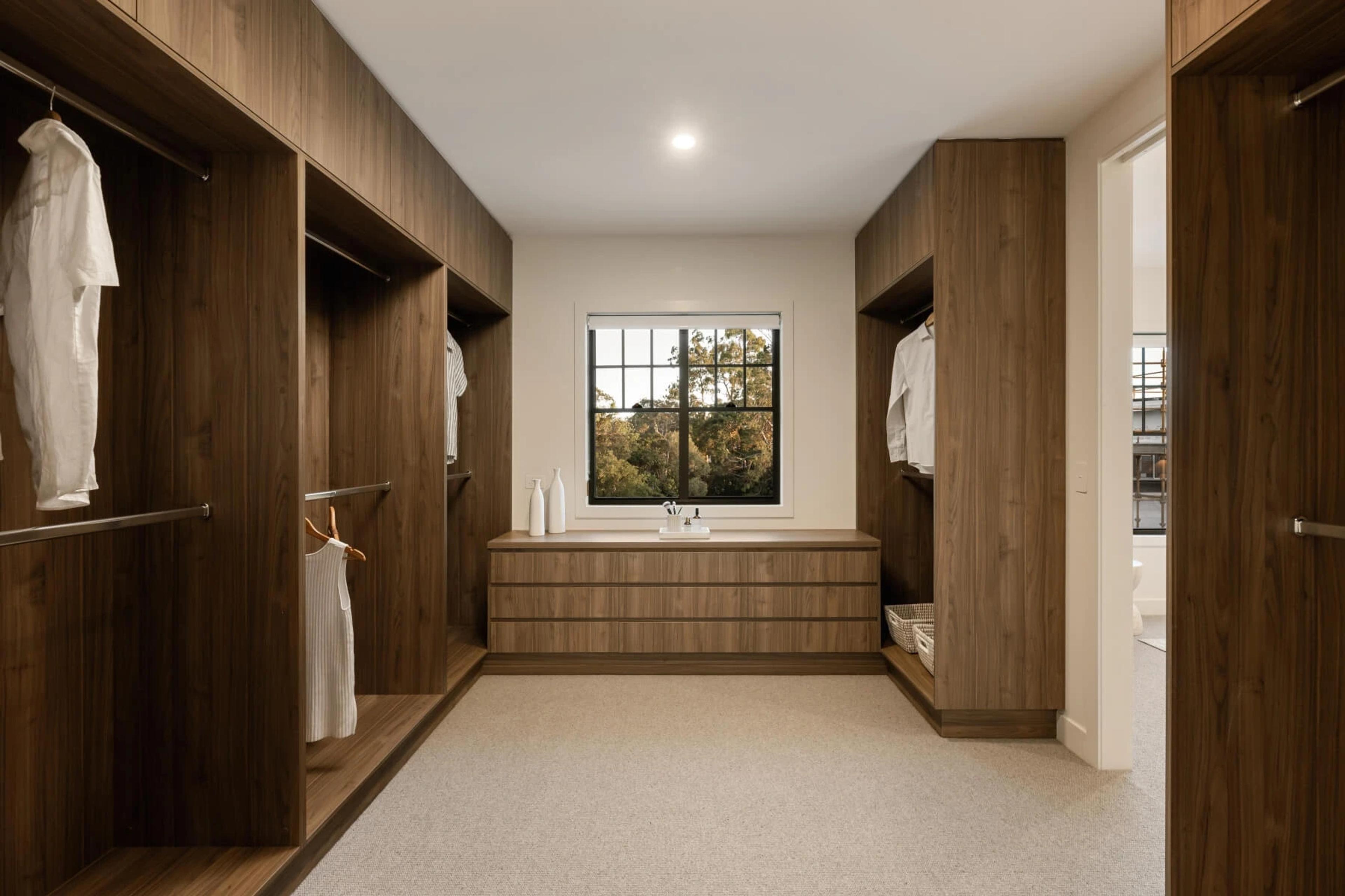 Walk in wardrobe with timber joinery and central drawers
