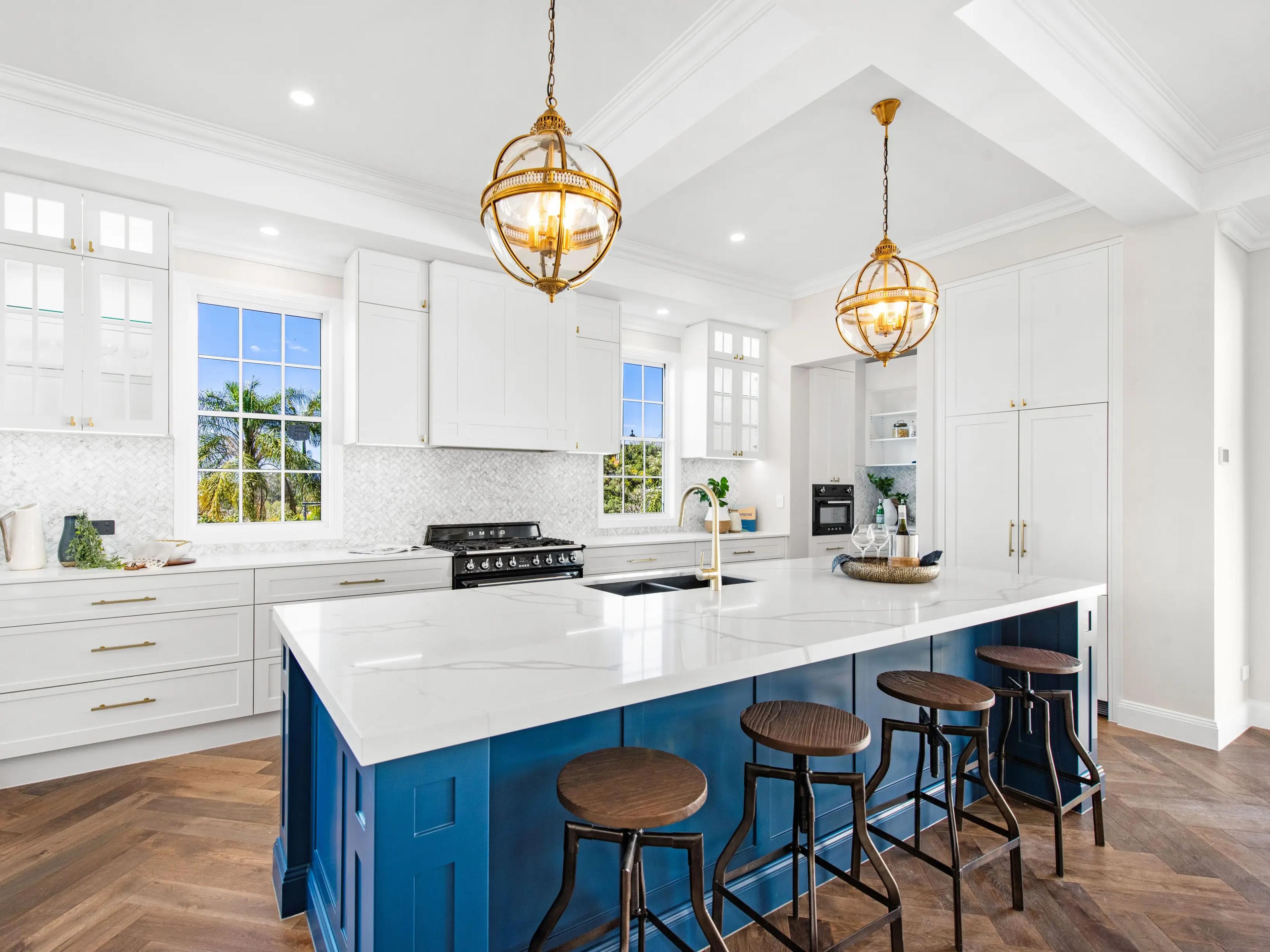 Kitchen with blue island, marble bench and stools
