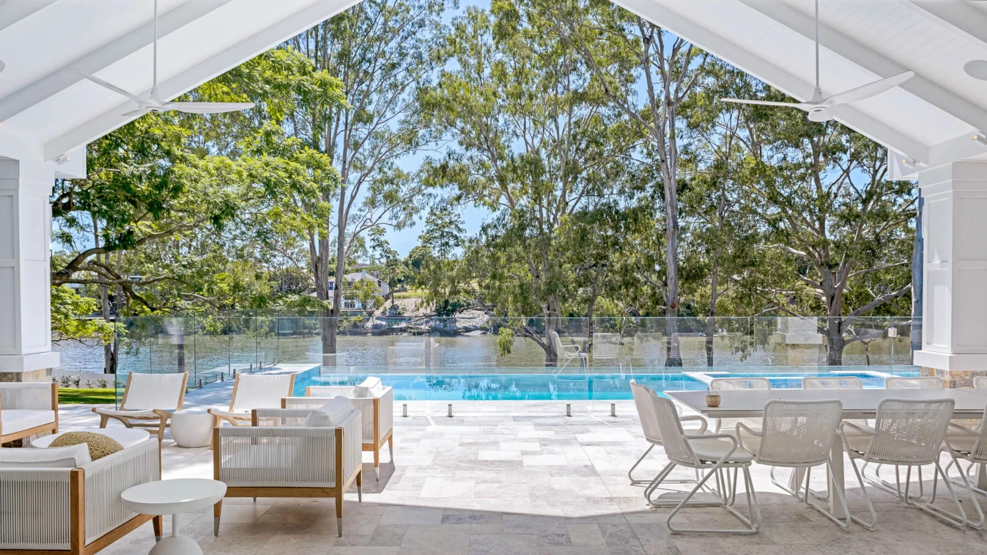 Covered terrace overlooking pool and river with lounge seating