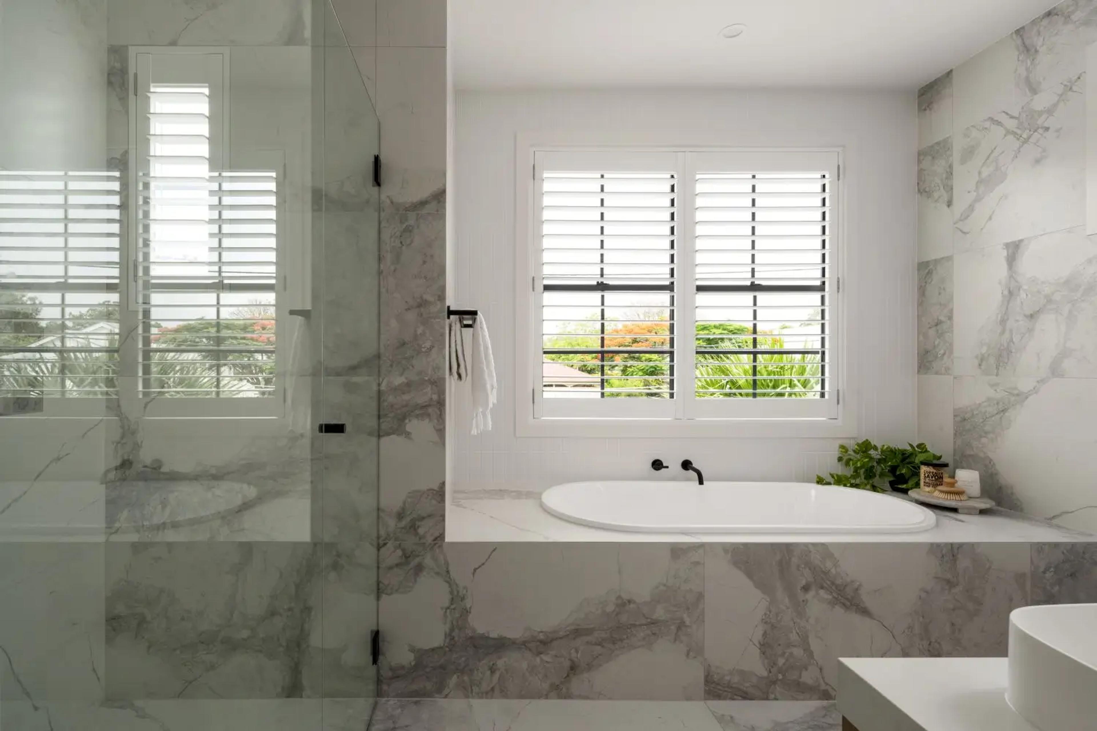 Marble ensuite with bathtub, shower and shuttered window