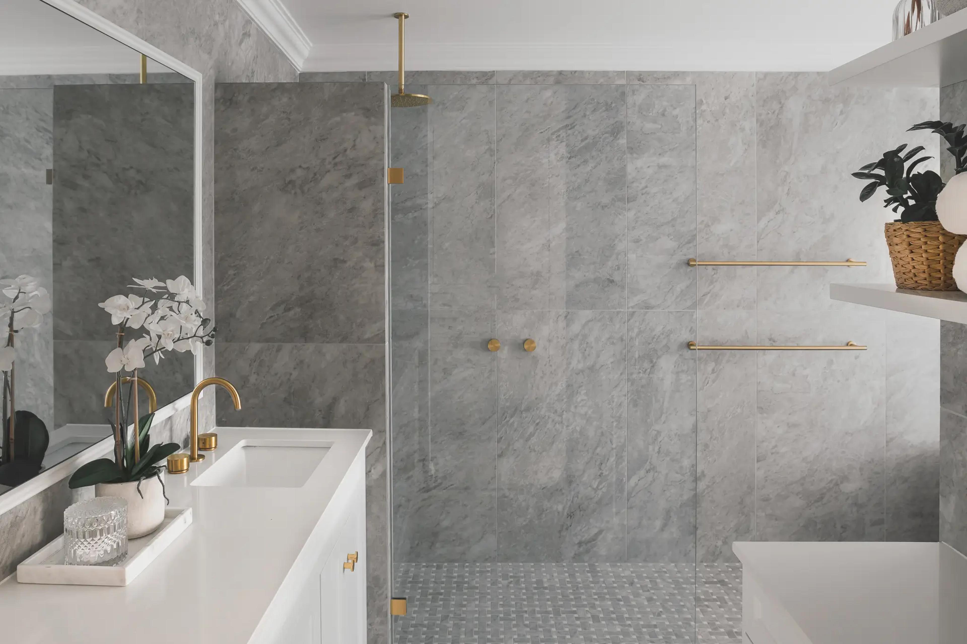Grey marble bathroom with double shower and brass tapware