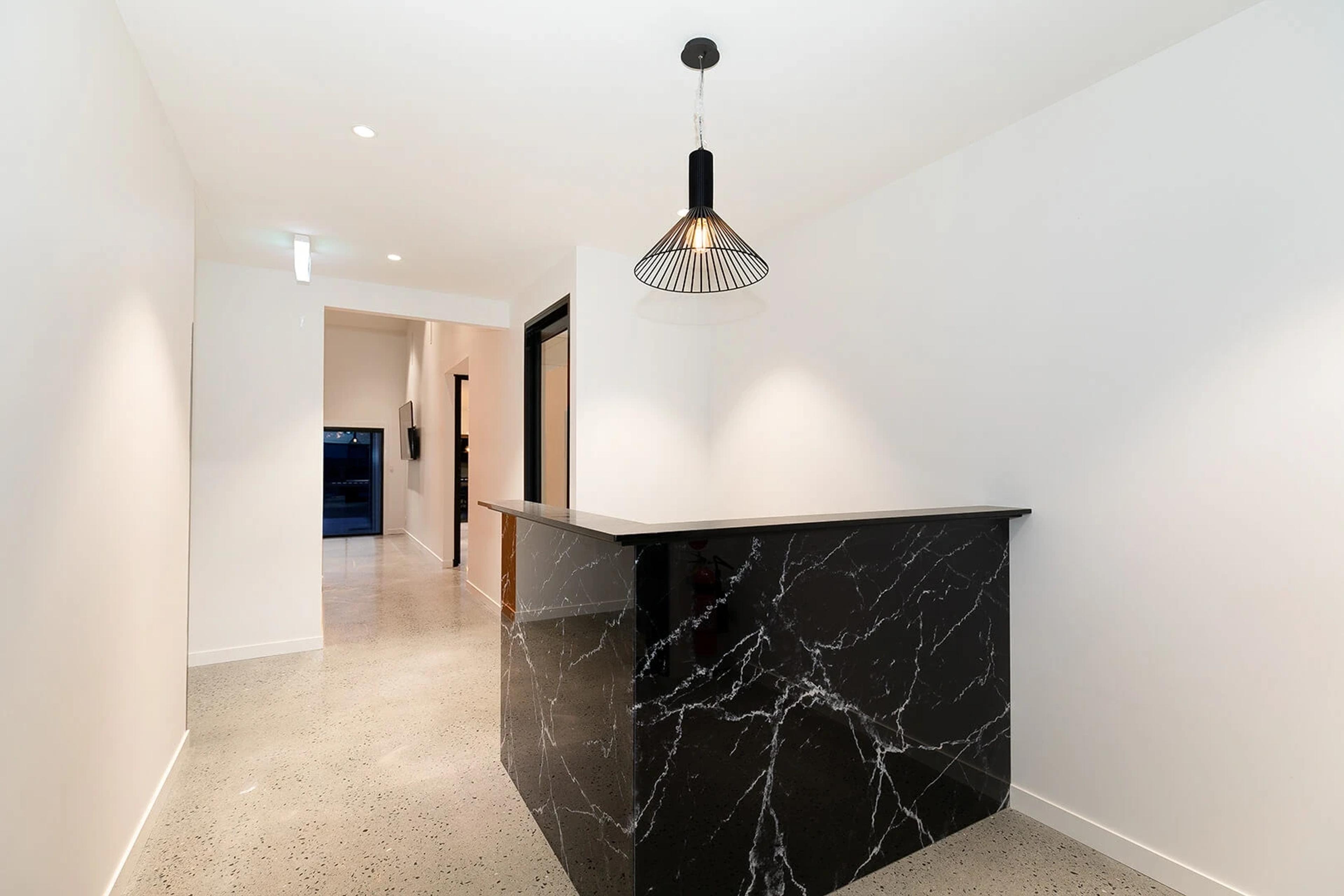 Reception area with black marble counter and pendant light
