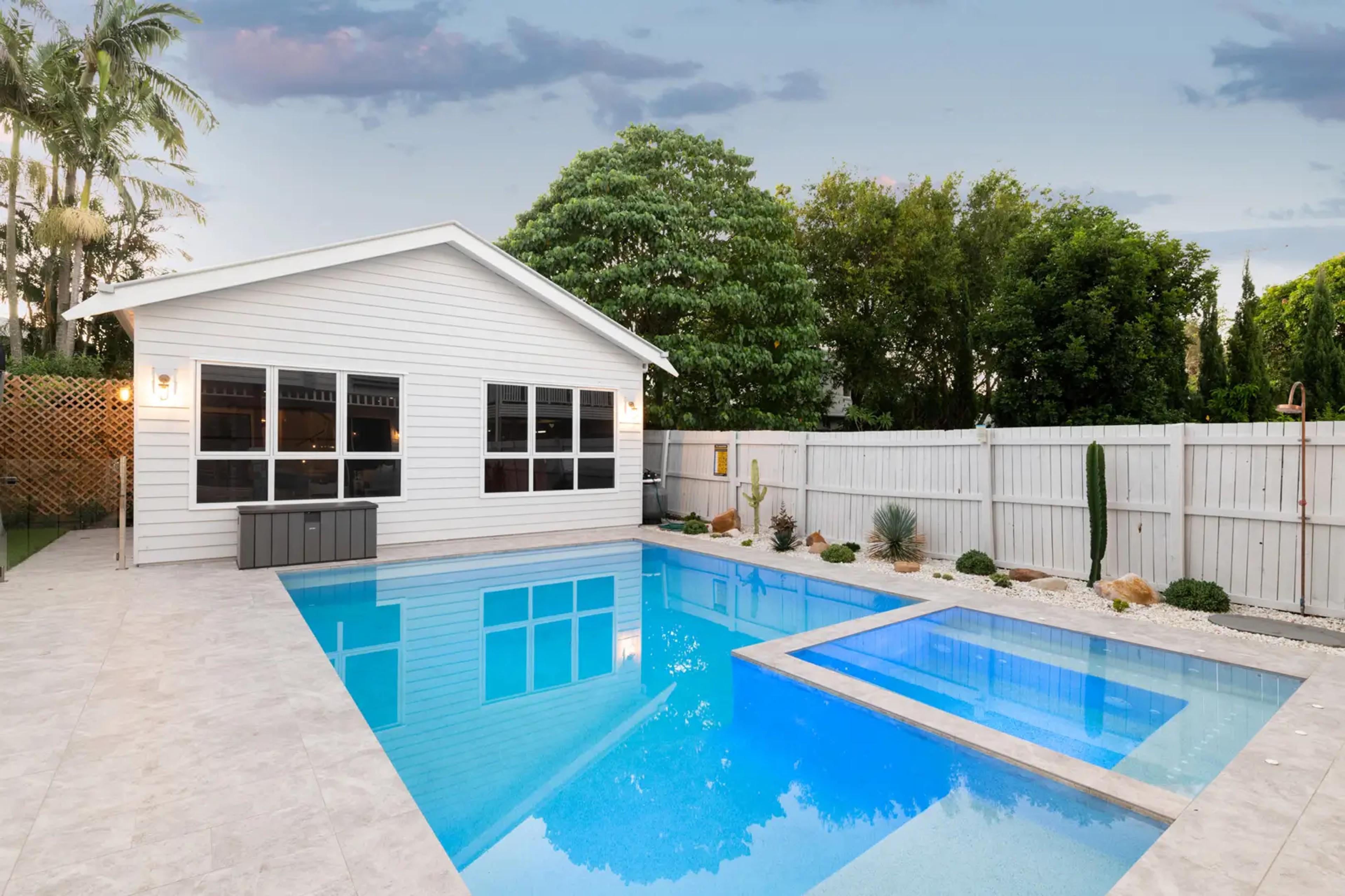Swimming pool beside white weatherboard pool house