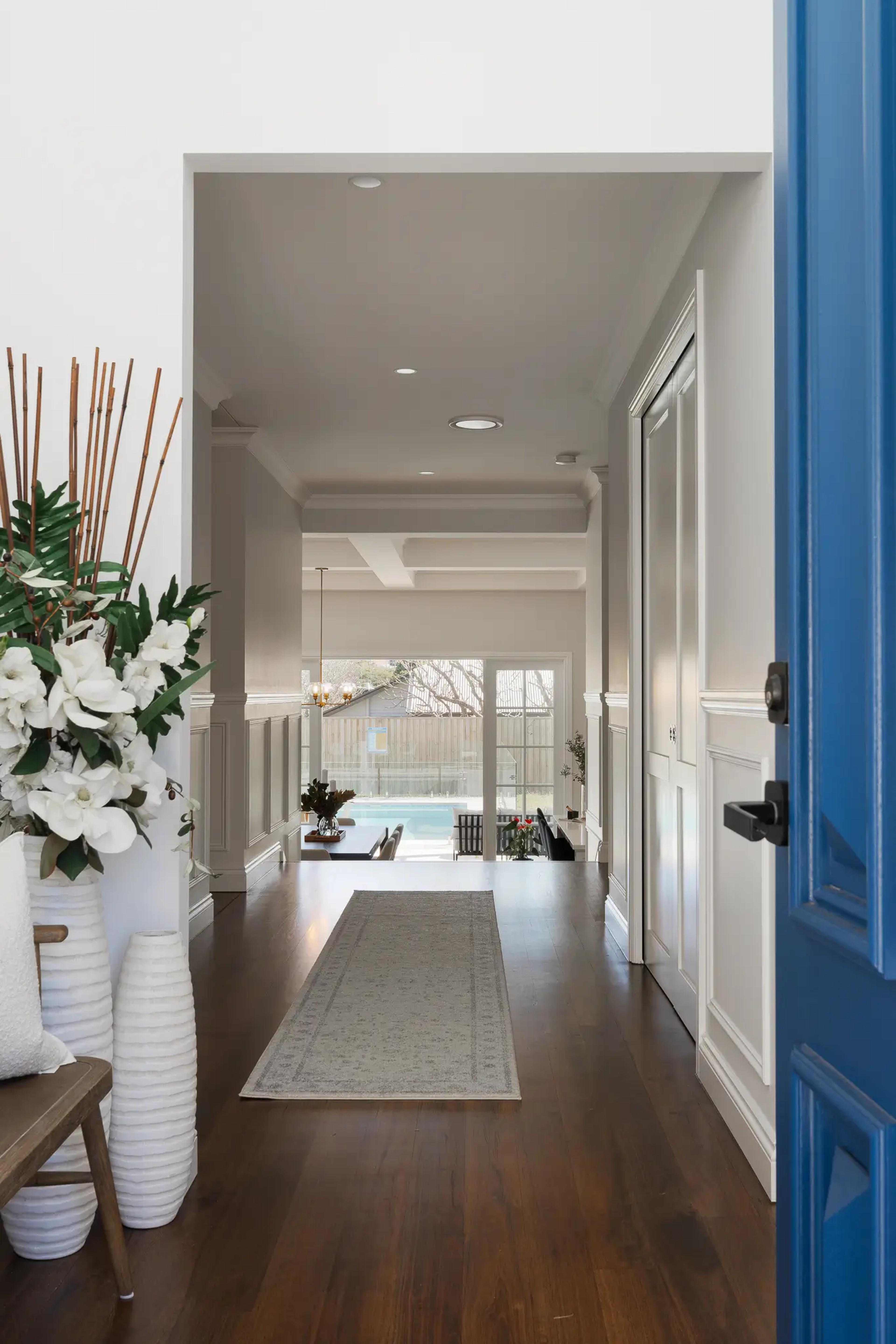 Entry hallway with blue front door and timber floor