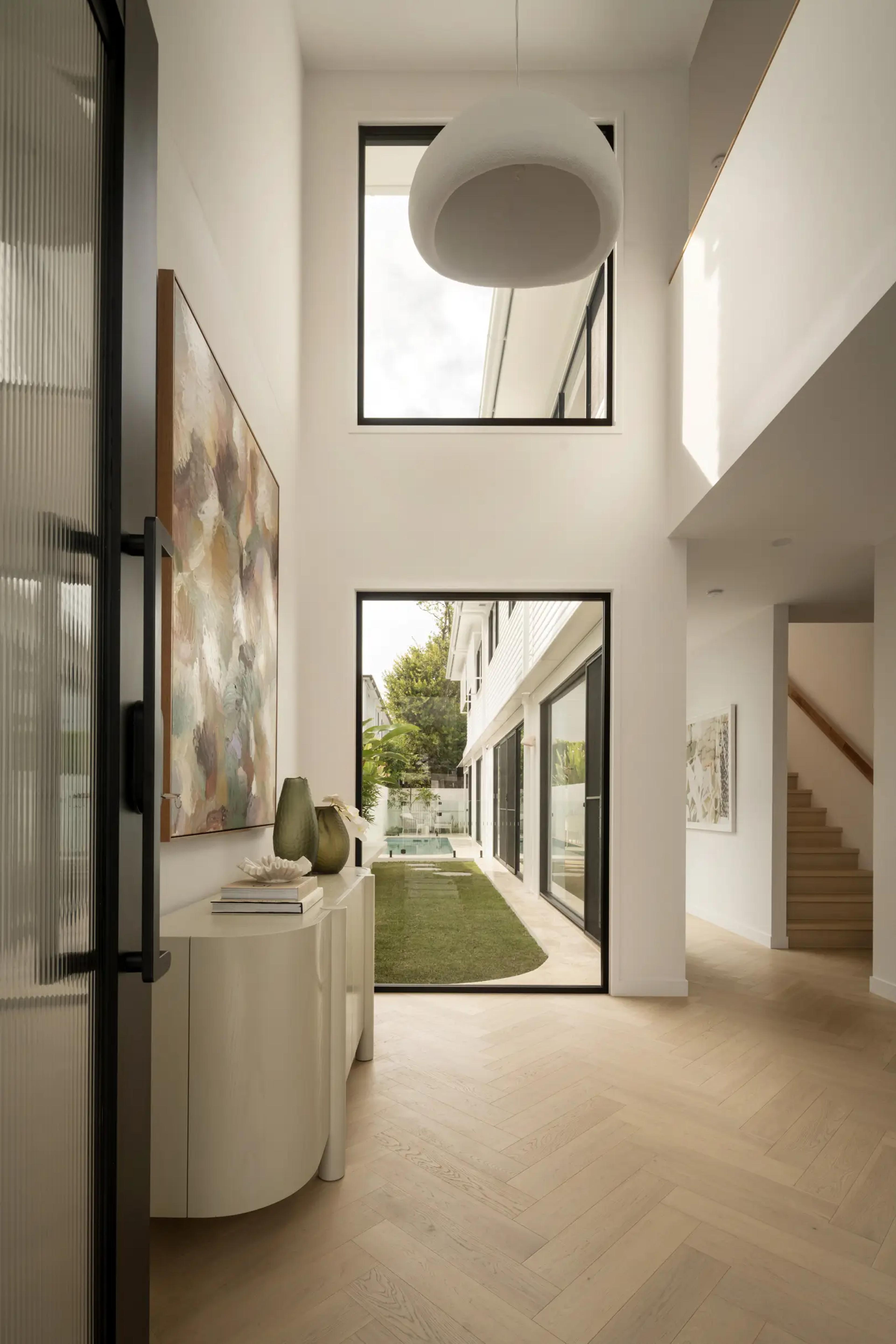 Double height entry hall with console and courtyard view