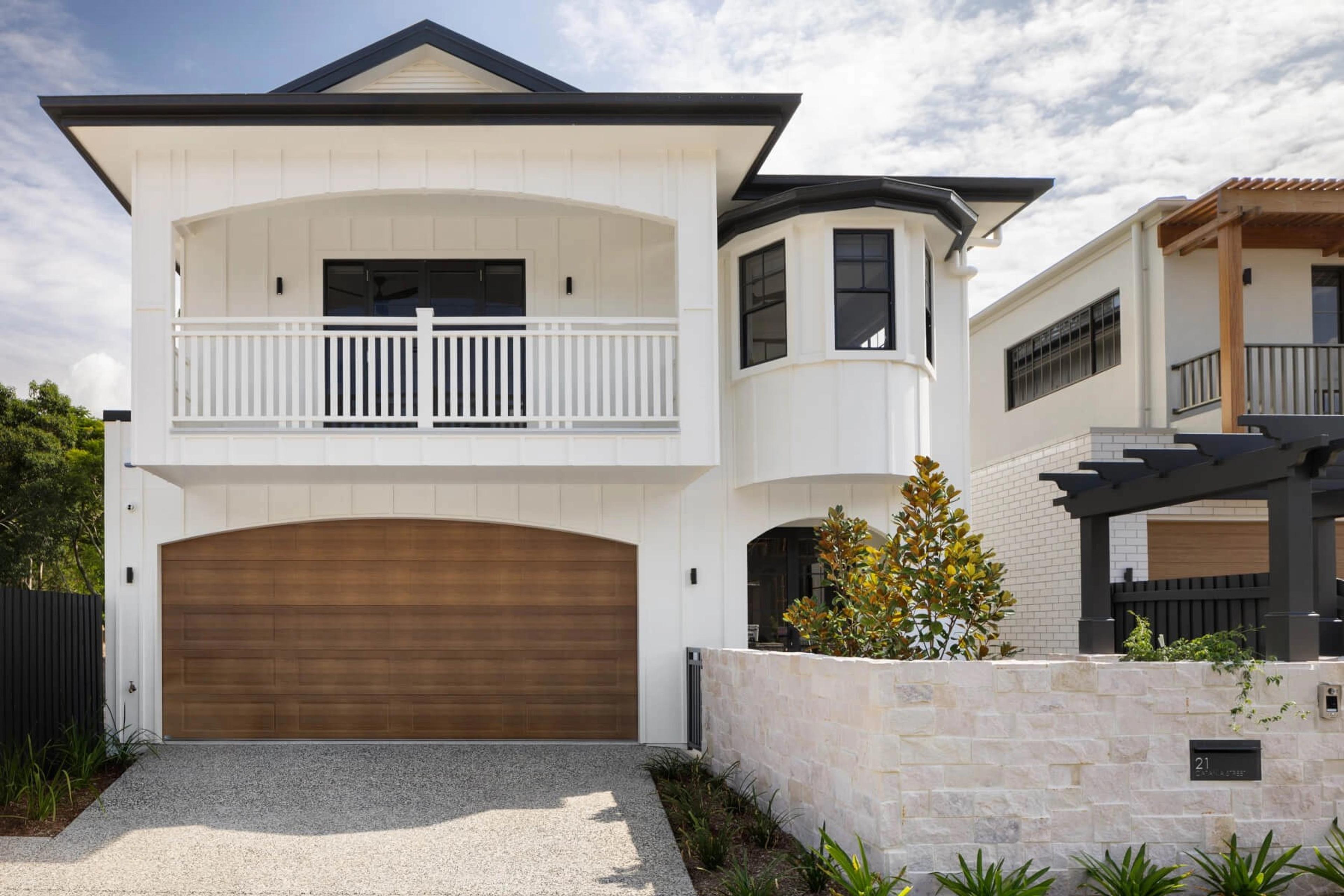 Two storey white home front elevation with timber garage door