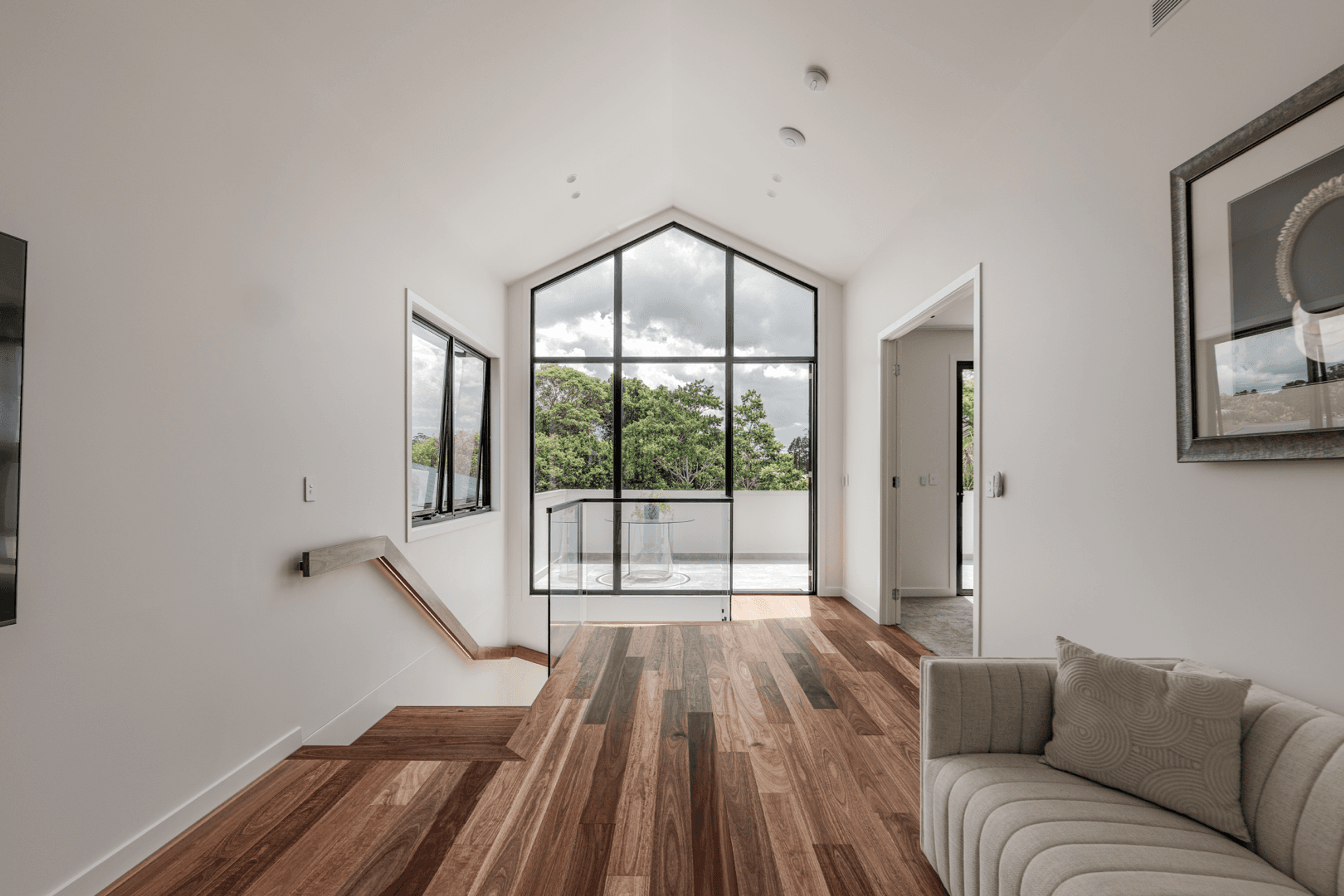 Upstairs sitting area with gabled window and timber floor