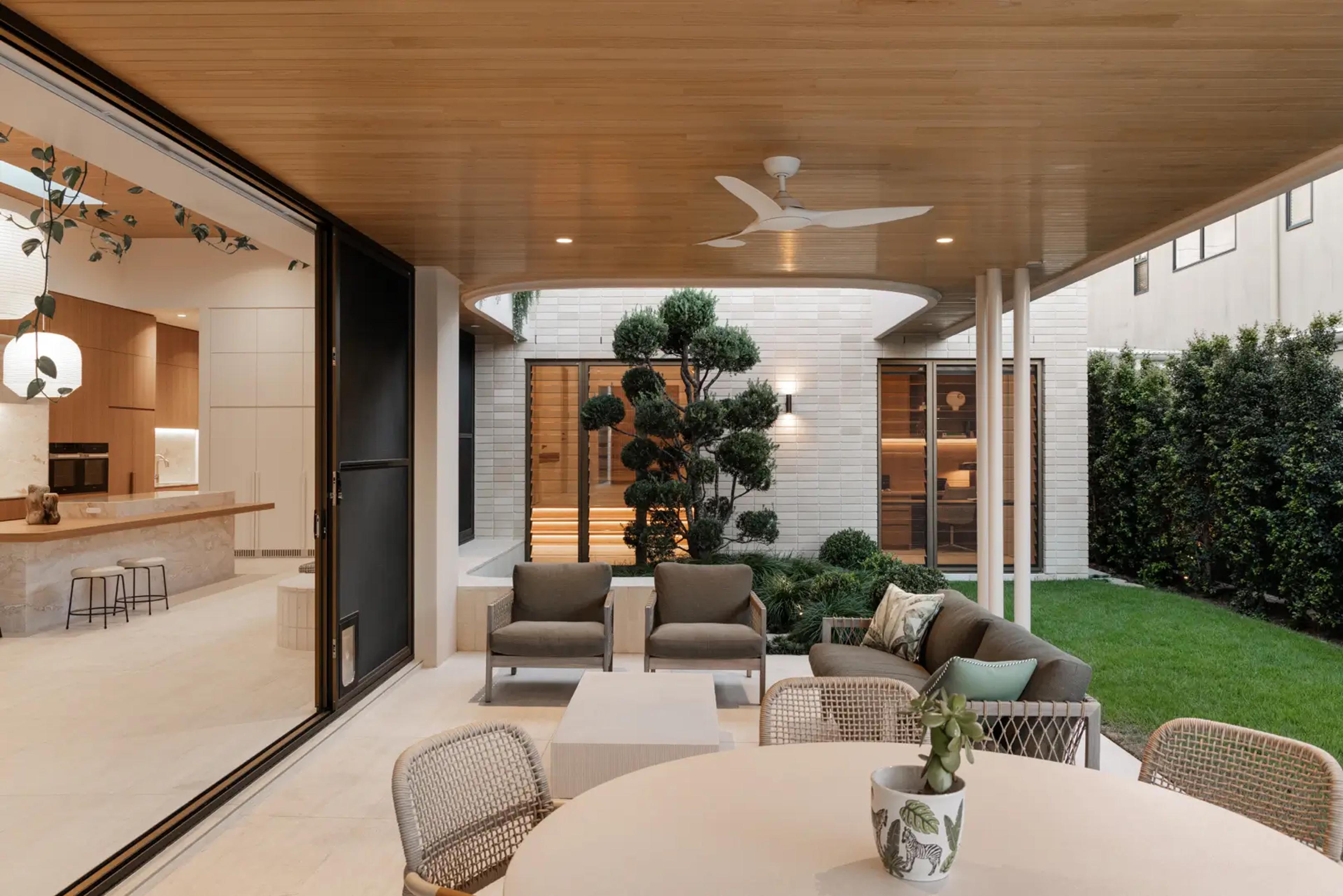 Outdoor lounge and dining terrace beside lawn and courtyard