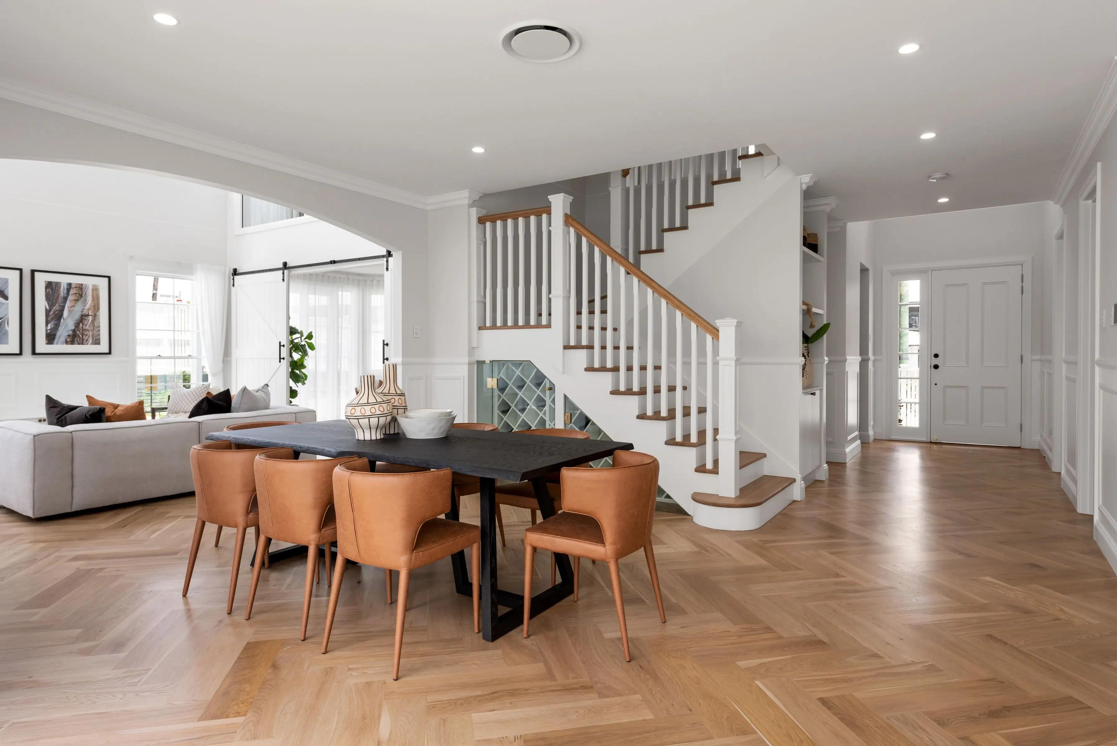 Open plan dining area with timber staircase and herringbone floor