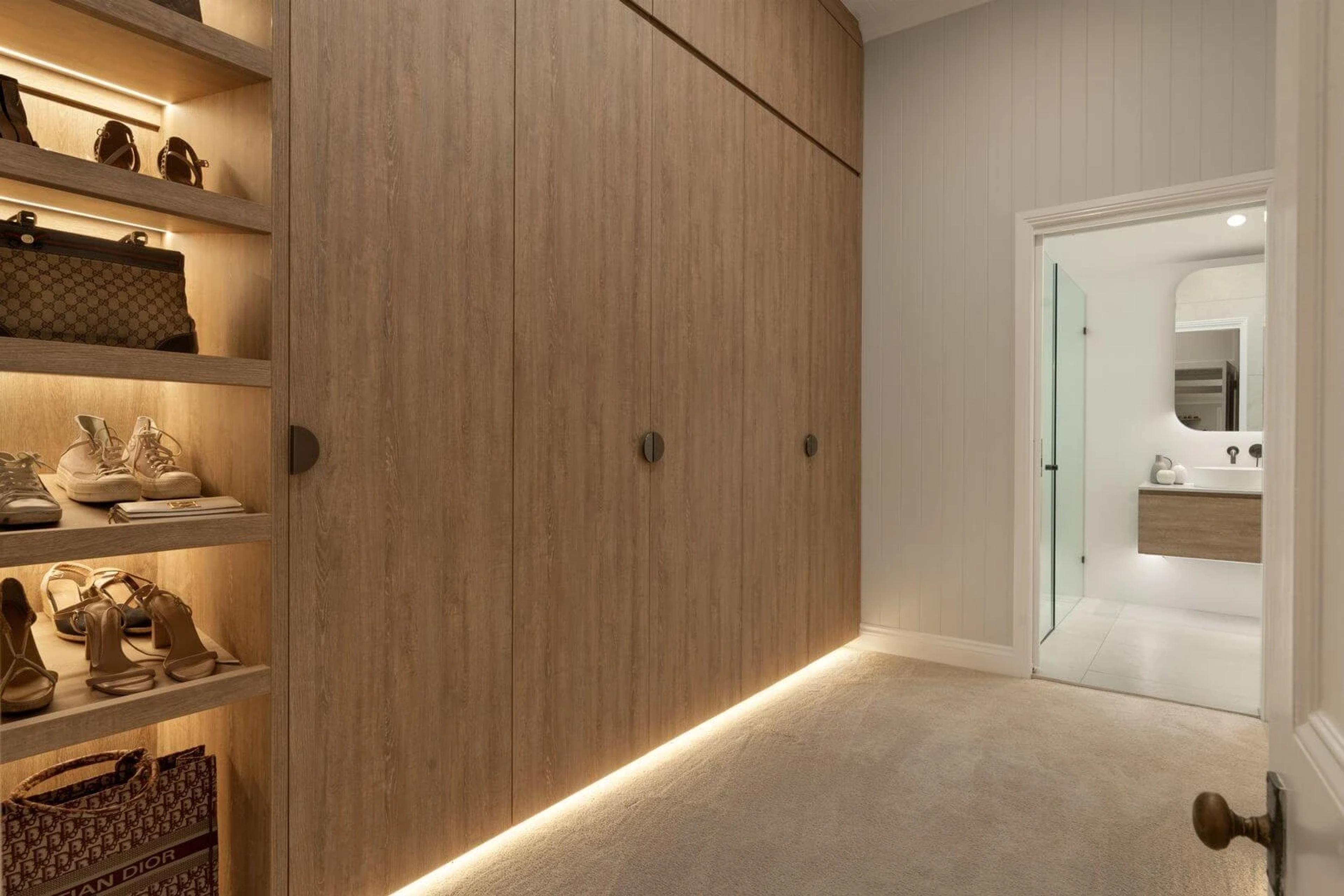 Walk in wardrobe with timber cabinetry leading to ensuite