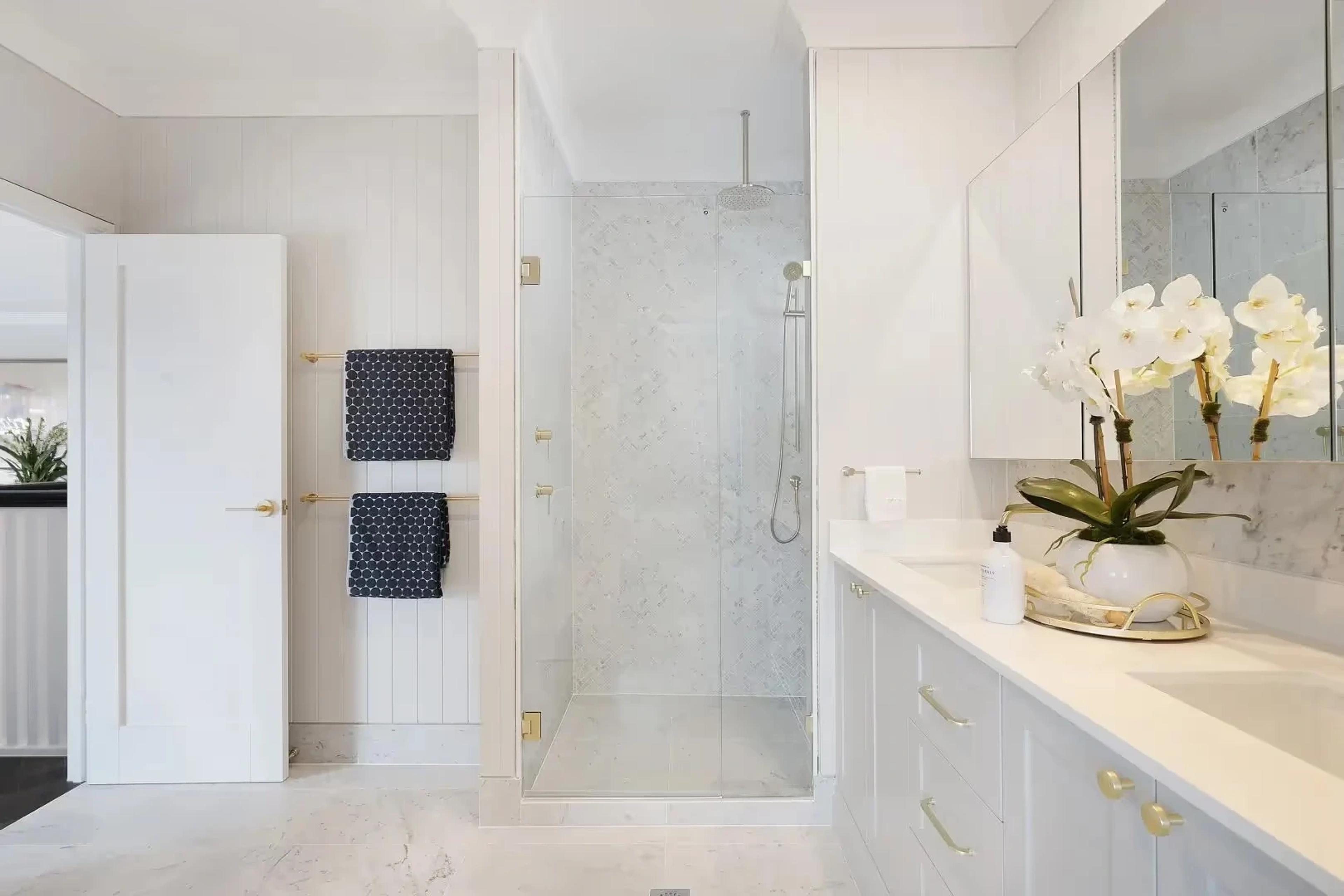 Bathroom with glass shower, double vanity and brass fittings