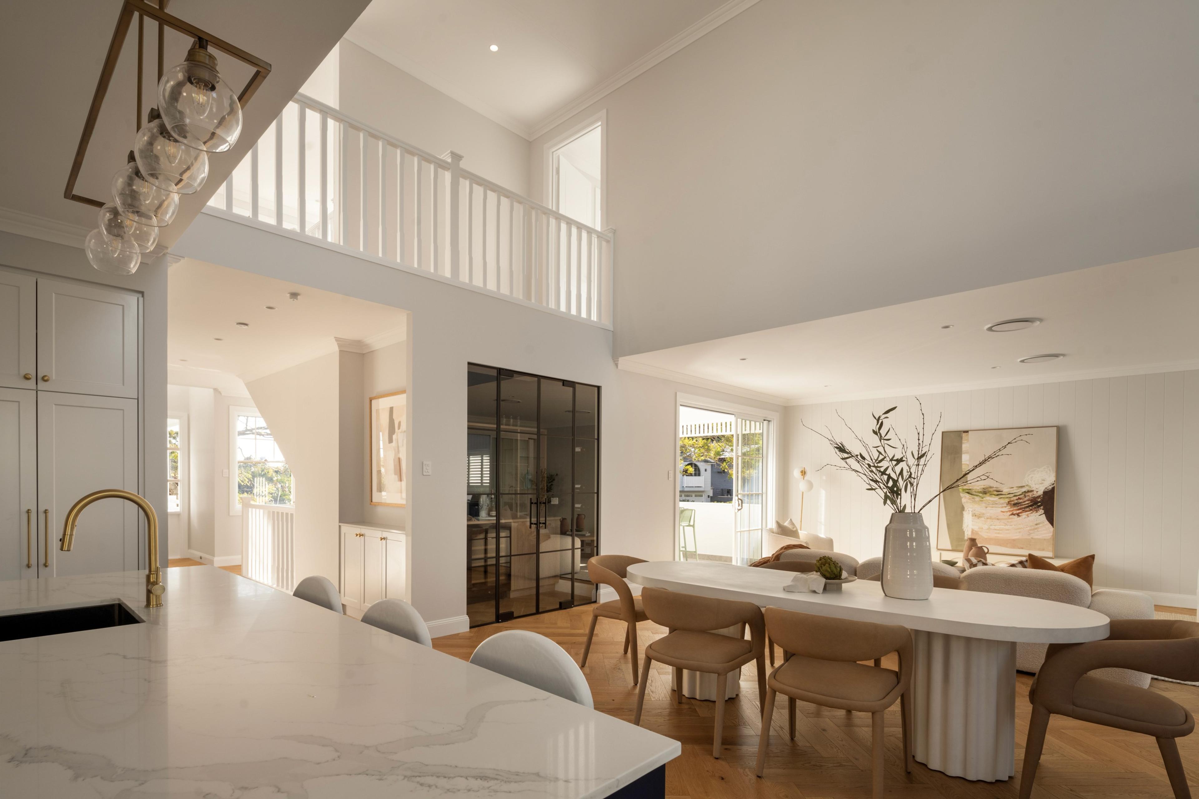 Open living and dining area beneath double height void and stairs