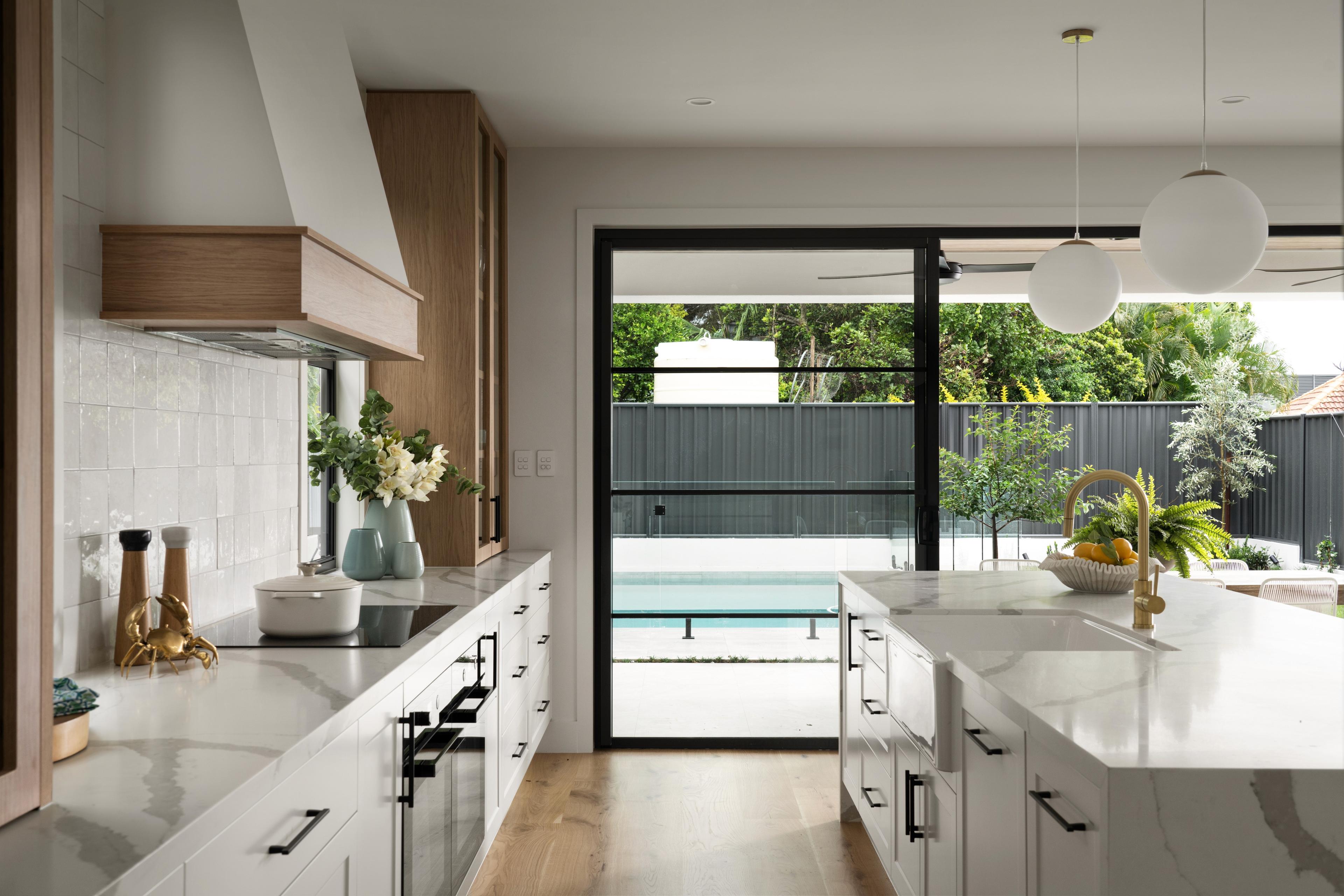 White kitchen with marble island and pool view