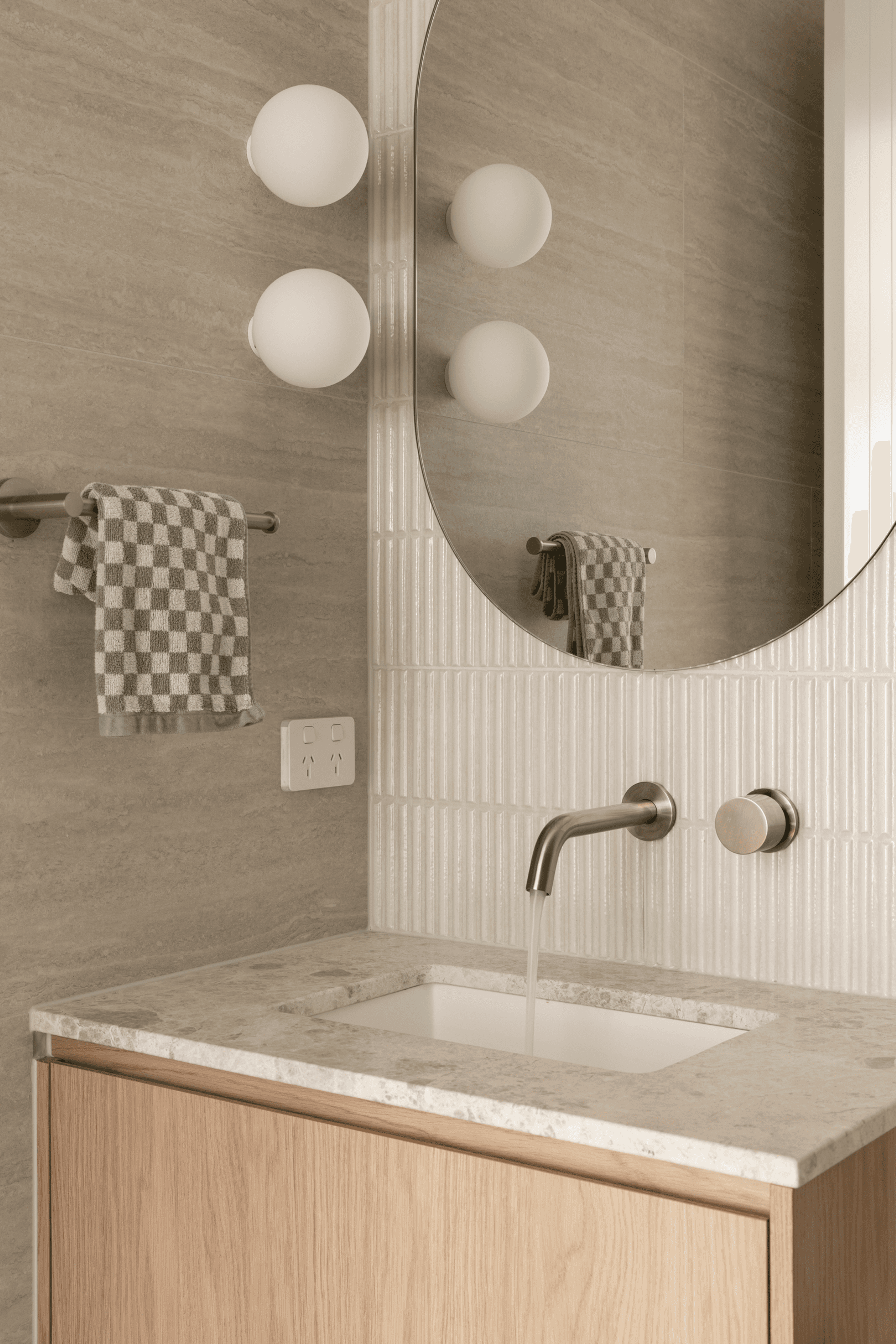 Powder room vanity with stone basin and round mirror