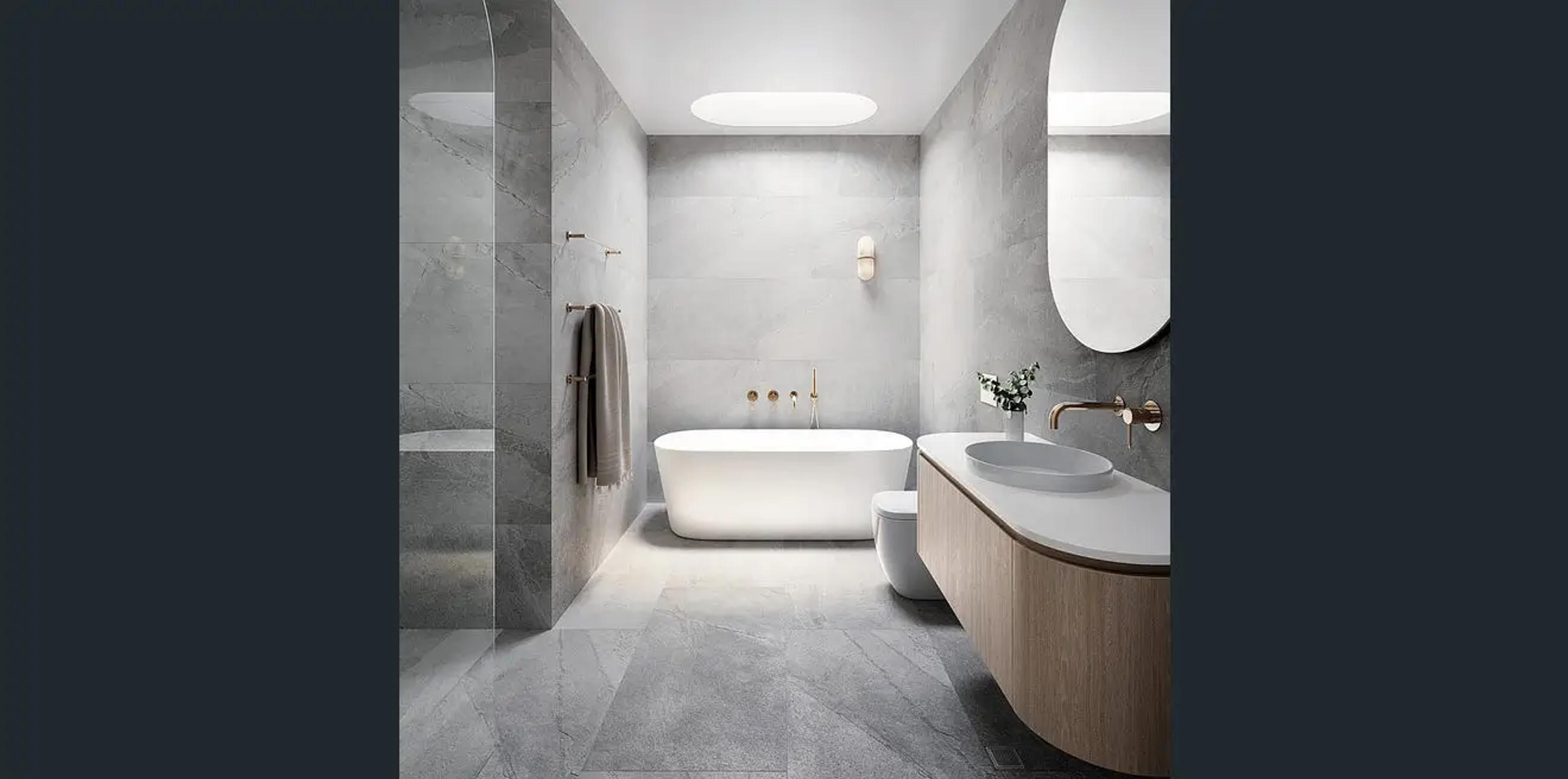 Stone tiled bathroom with freestanding bath and timber vanity