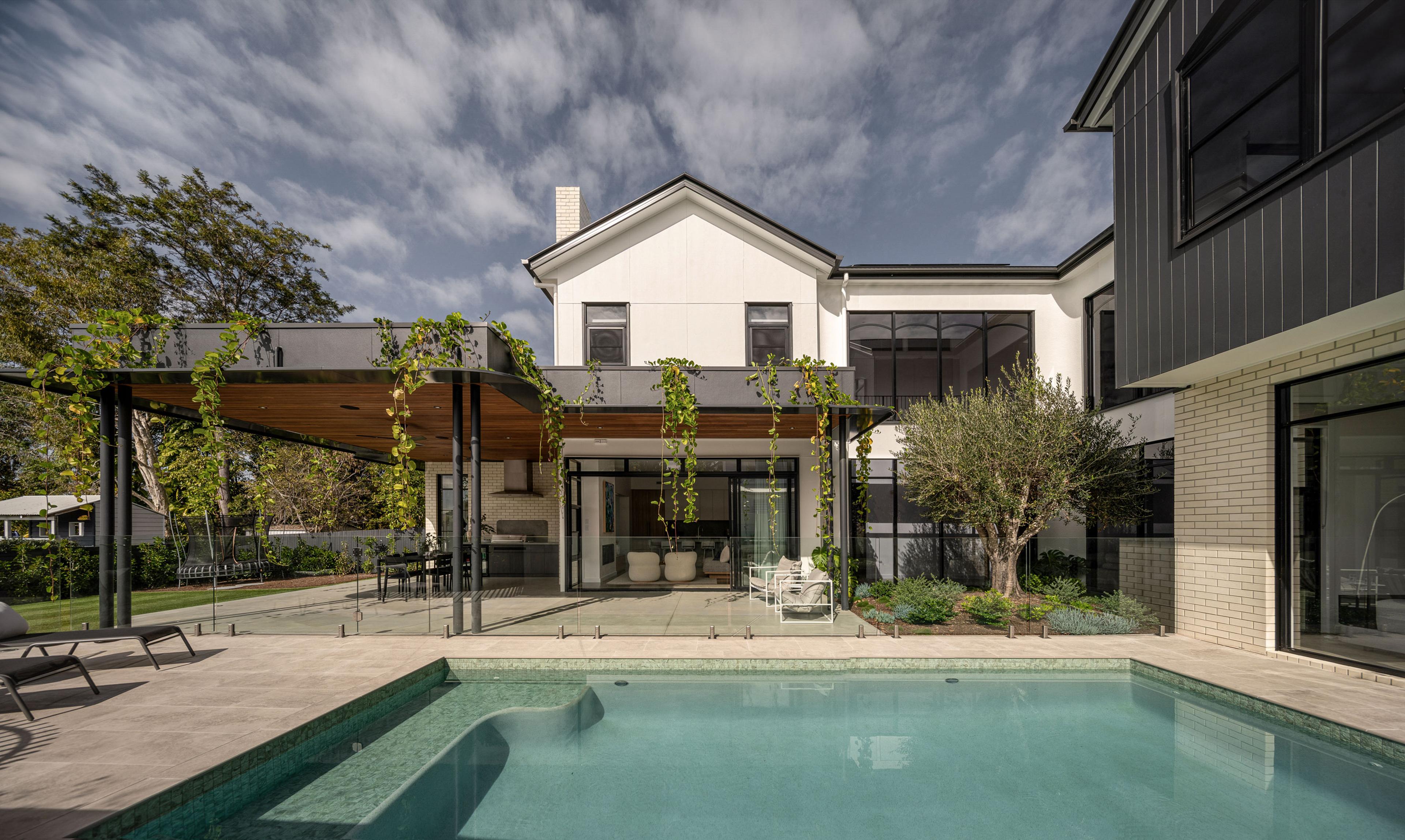 Backyard swimming pool with vine covered pergola and dining area