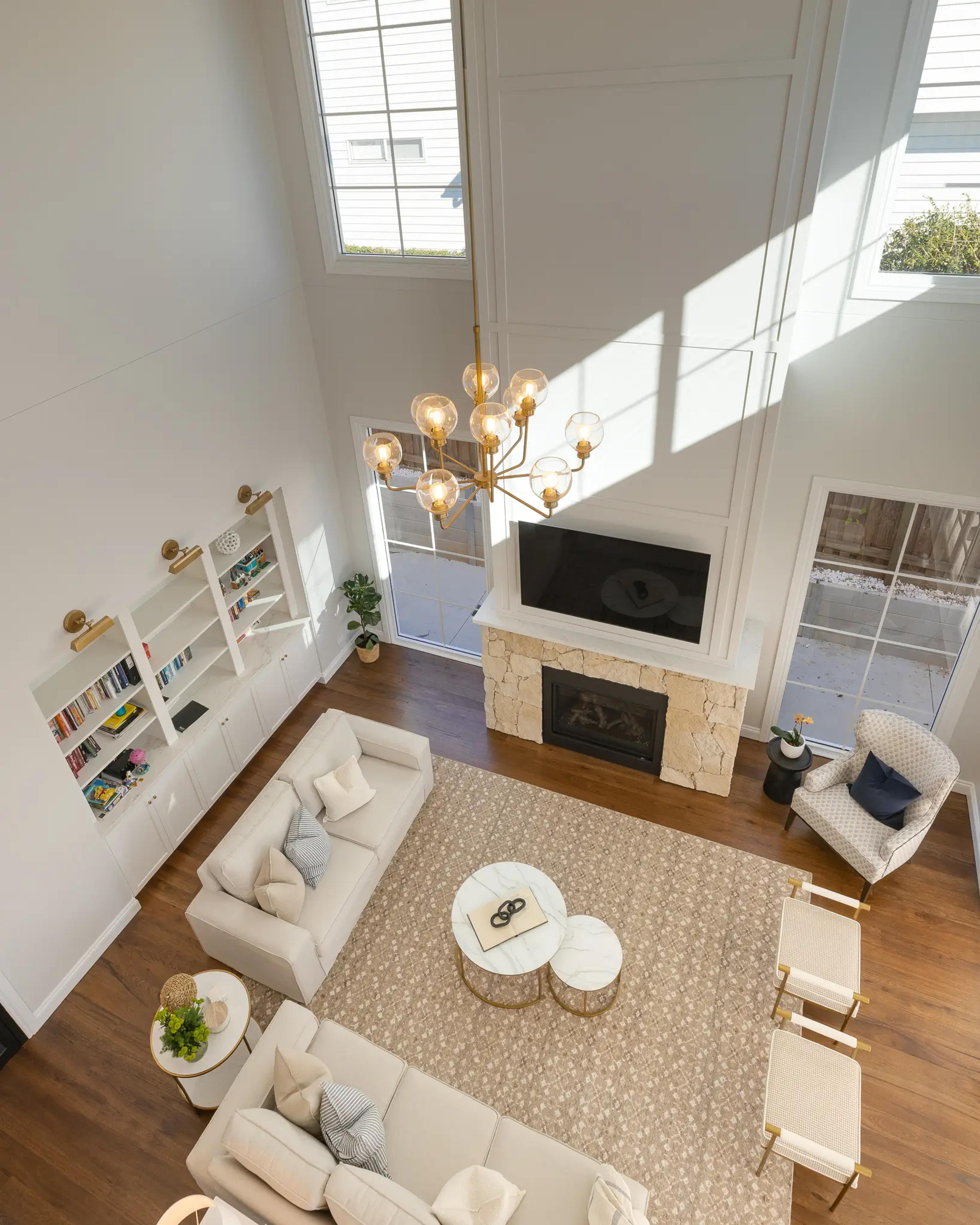 Aerial view of double height living room with stone fireplace