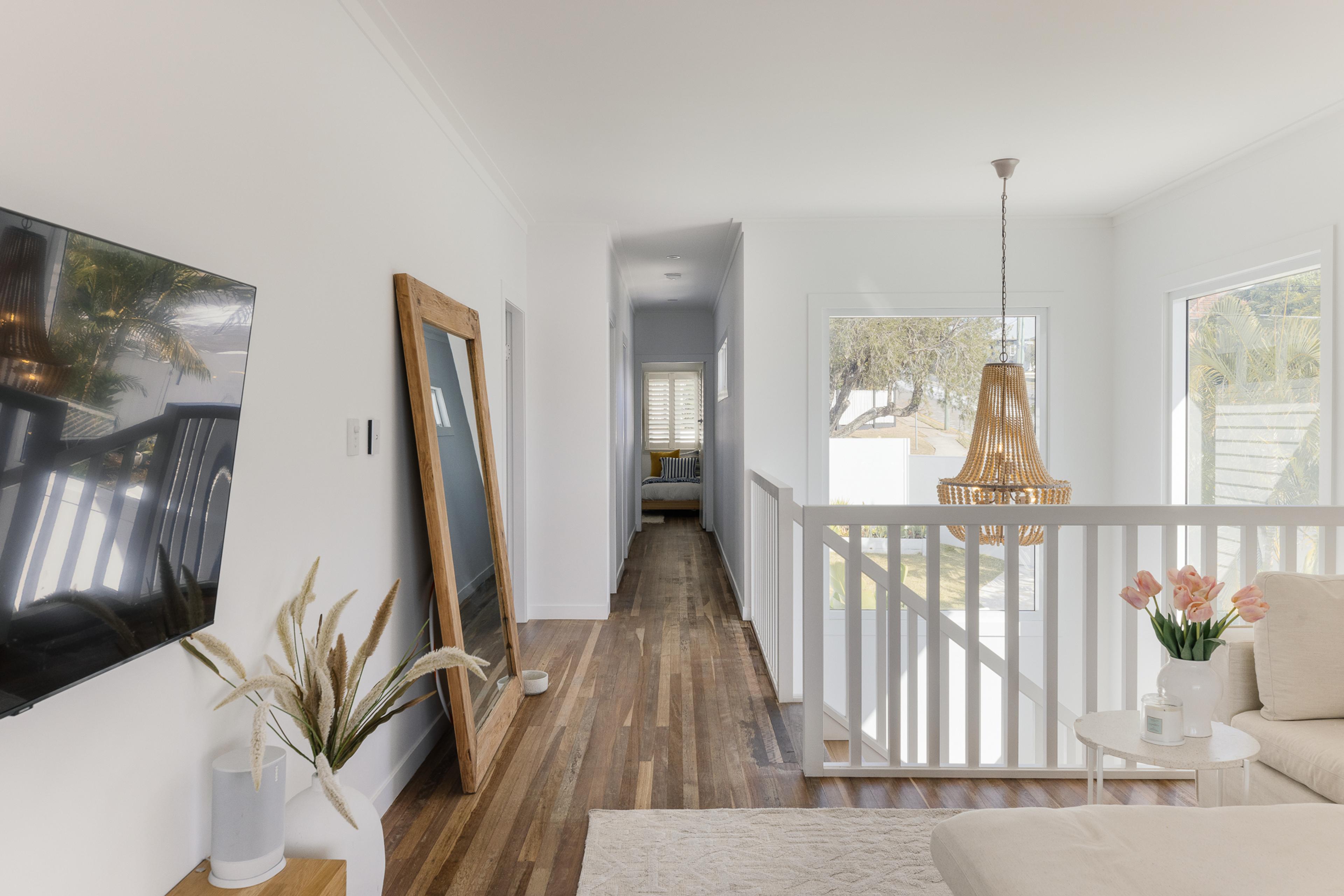 Upstairs landing looking along the hallway, with timber floors and a beaded chandelier over the stair