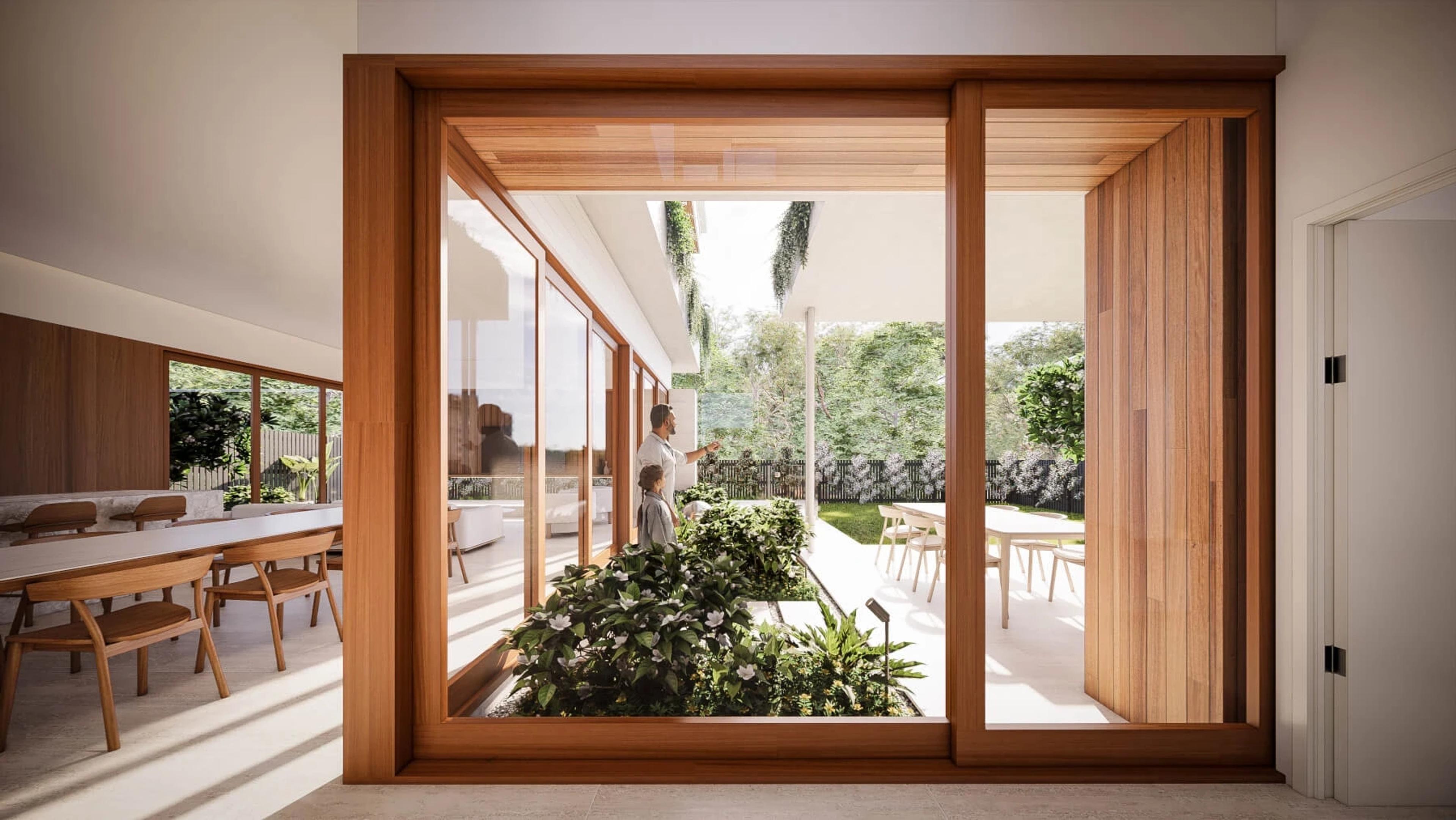 Interior view through timber framed sliding doors to garden courtyard