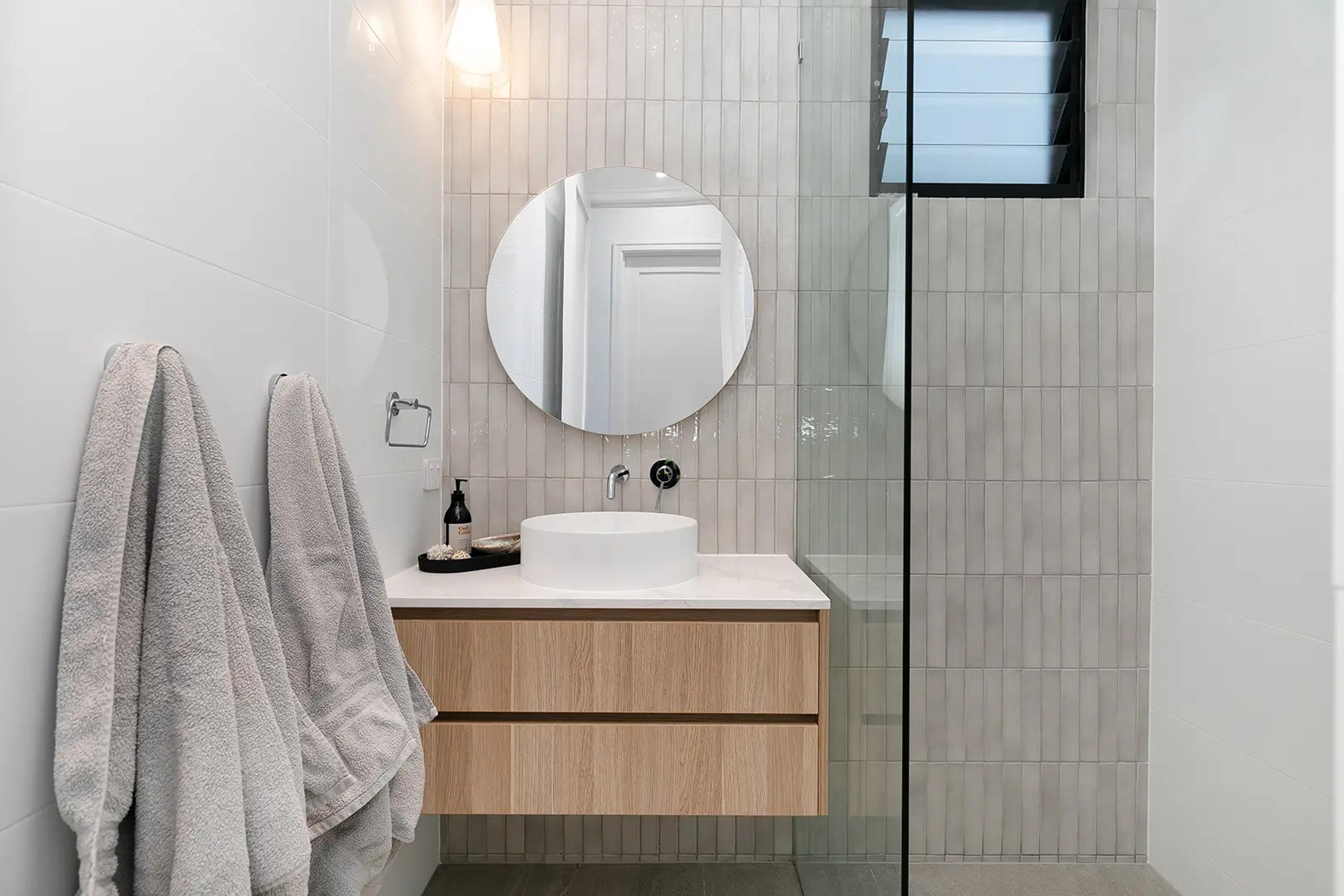 Bathroom with round mirror, timber vanity and vessel basin