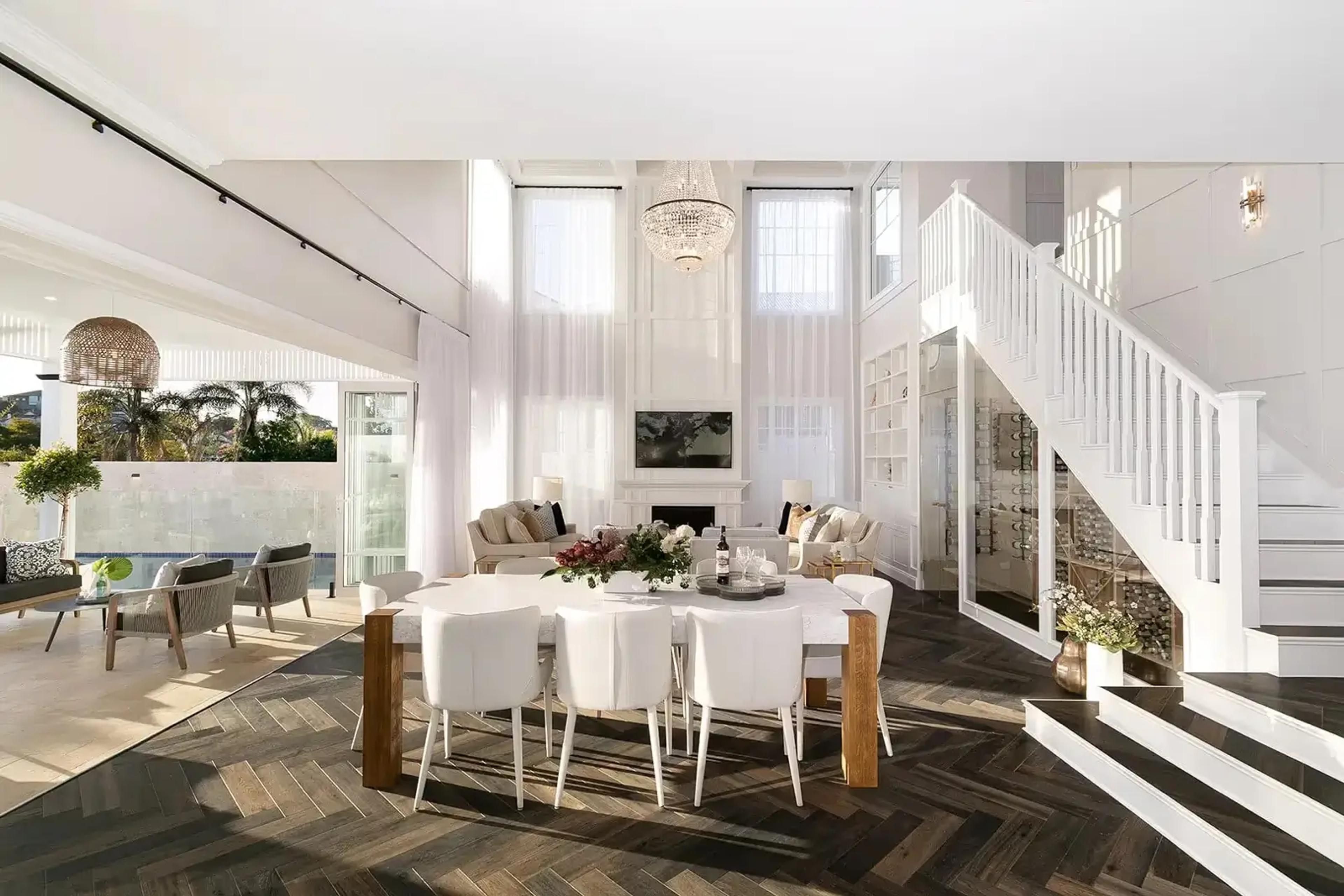 Double height living and dining room with staircase and chandelier