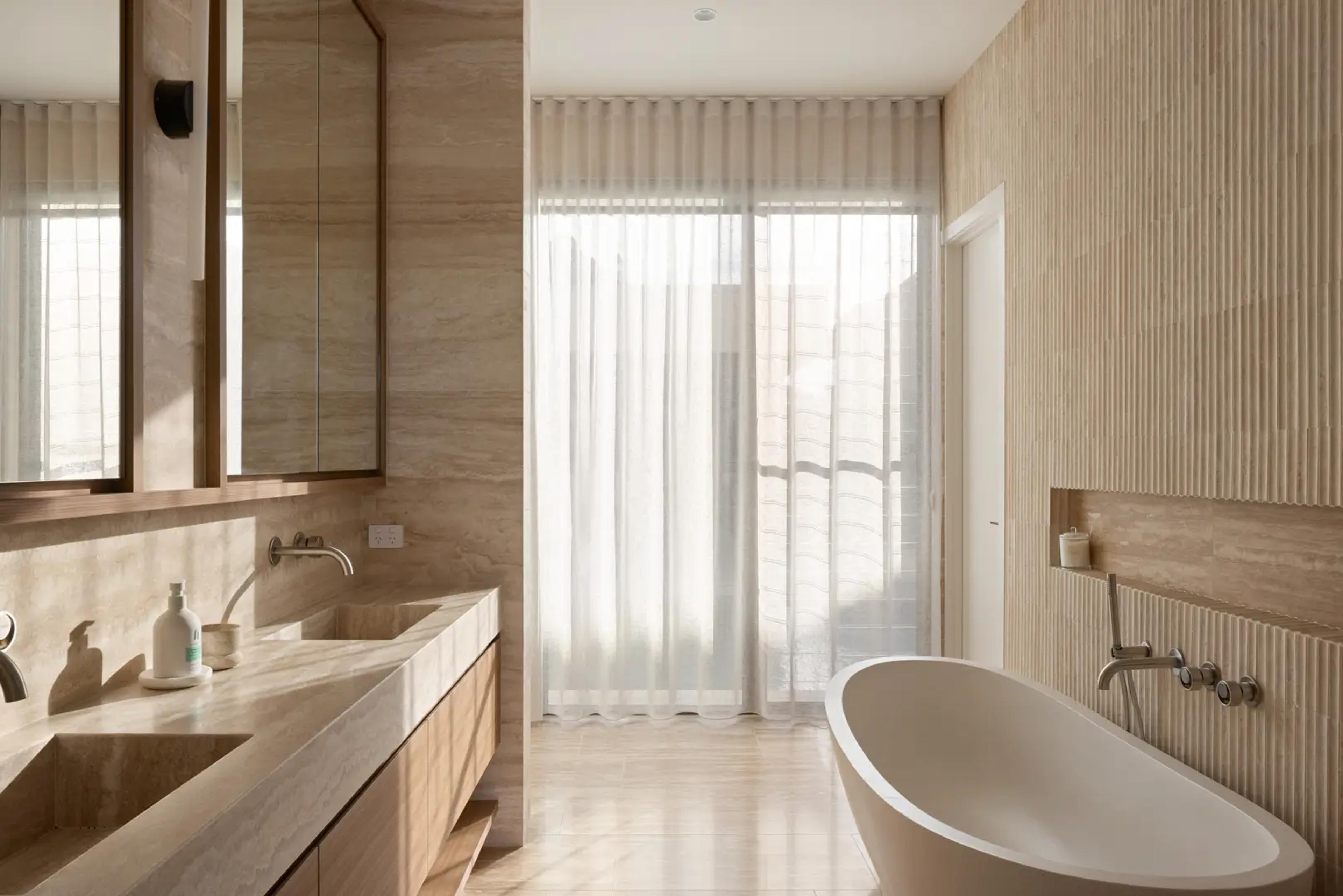 Ensuite with stone vanity and freestanding bath by window