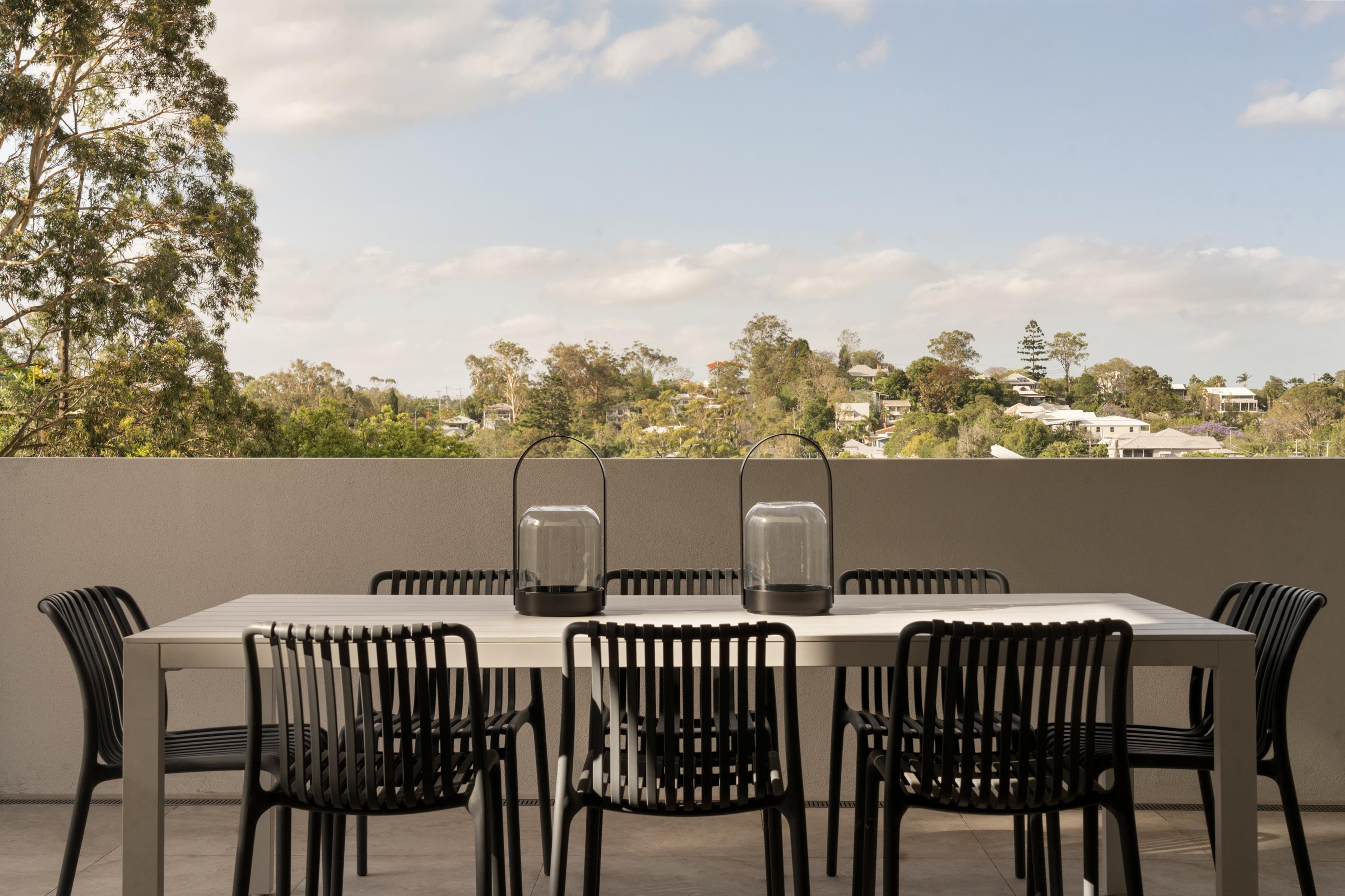 Balcony dining table overlooking leafy suburban valley