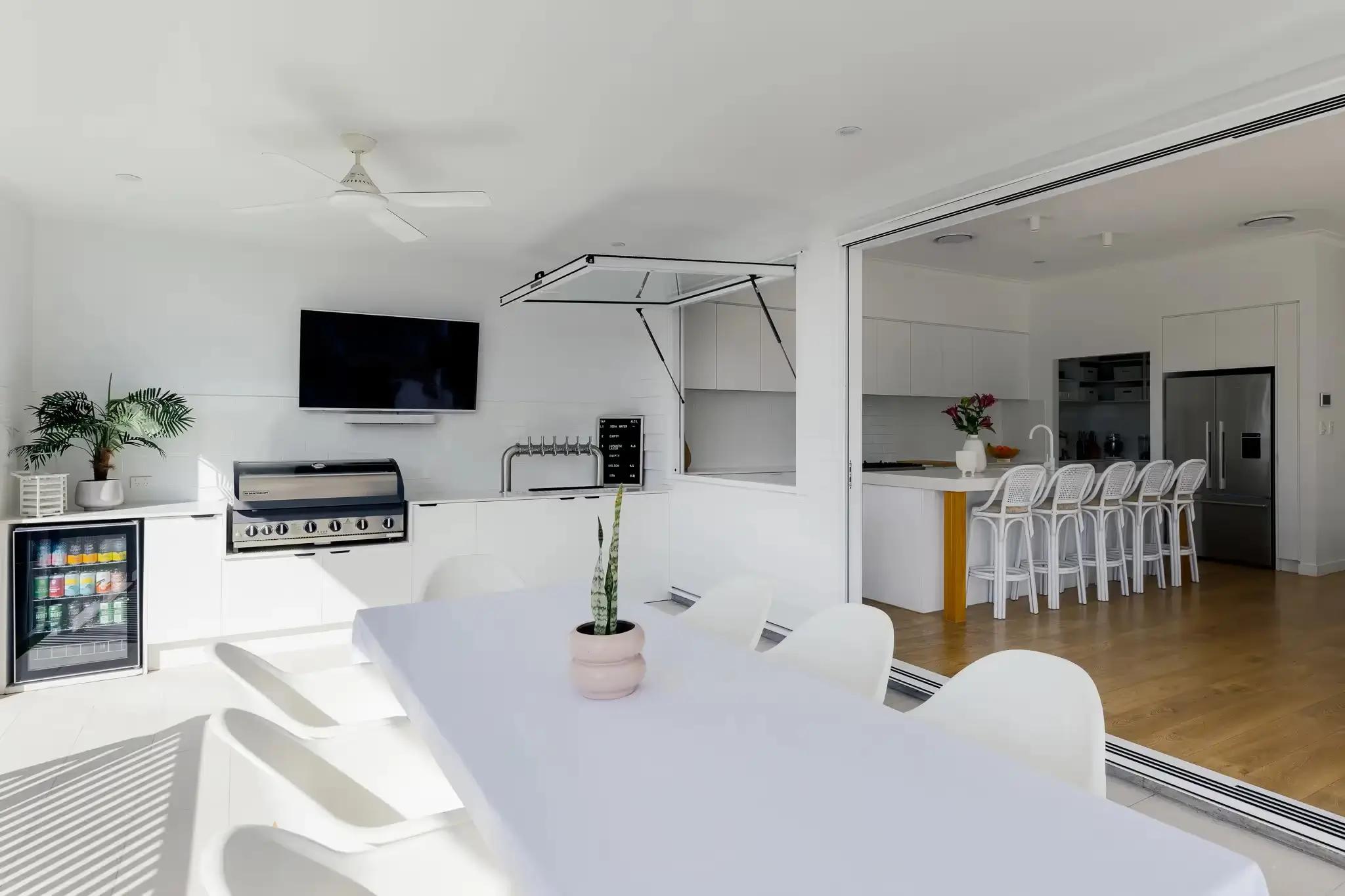 Outdoor entertainment area with an awning from the kitchen and fully equipped outdoor kitchen and built in bbq