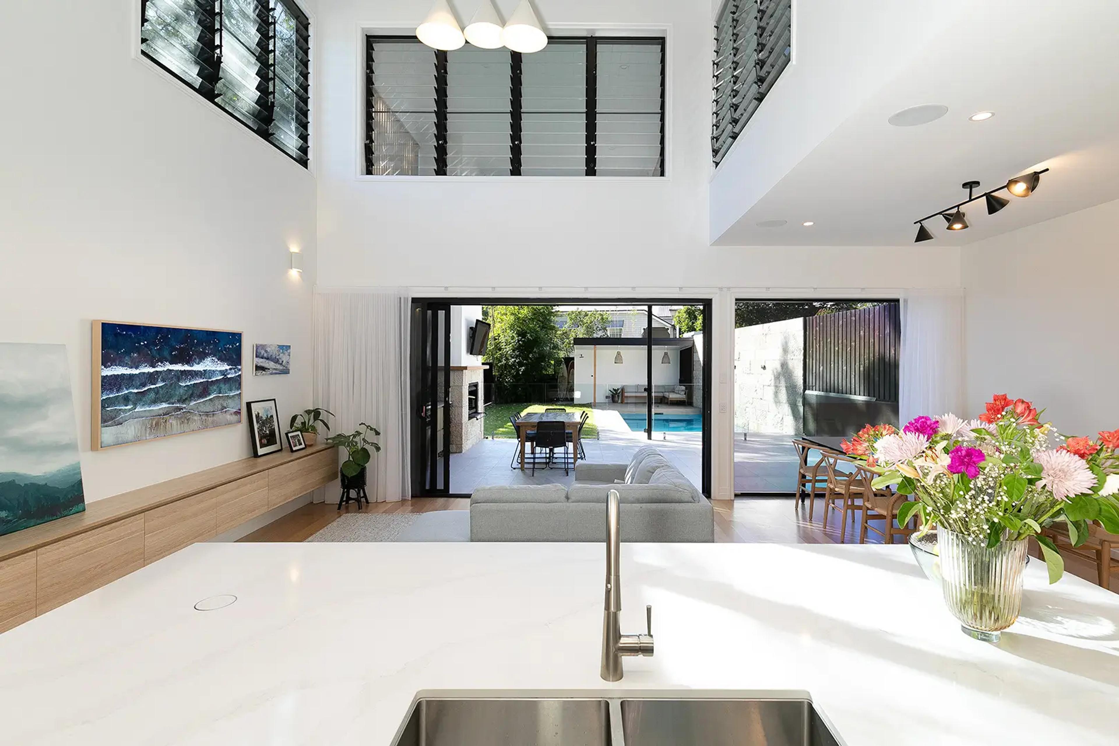 Kitchen island looking through bifold doors to pool and backyard