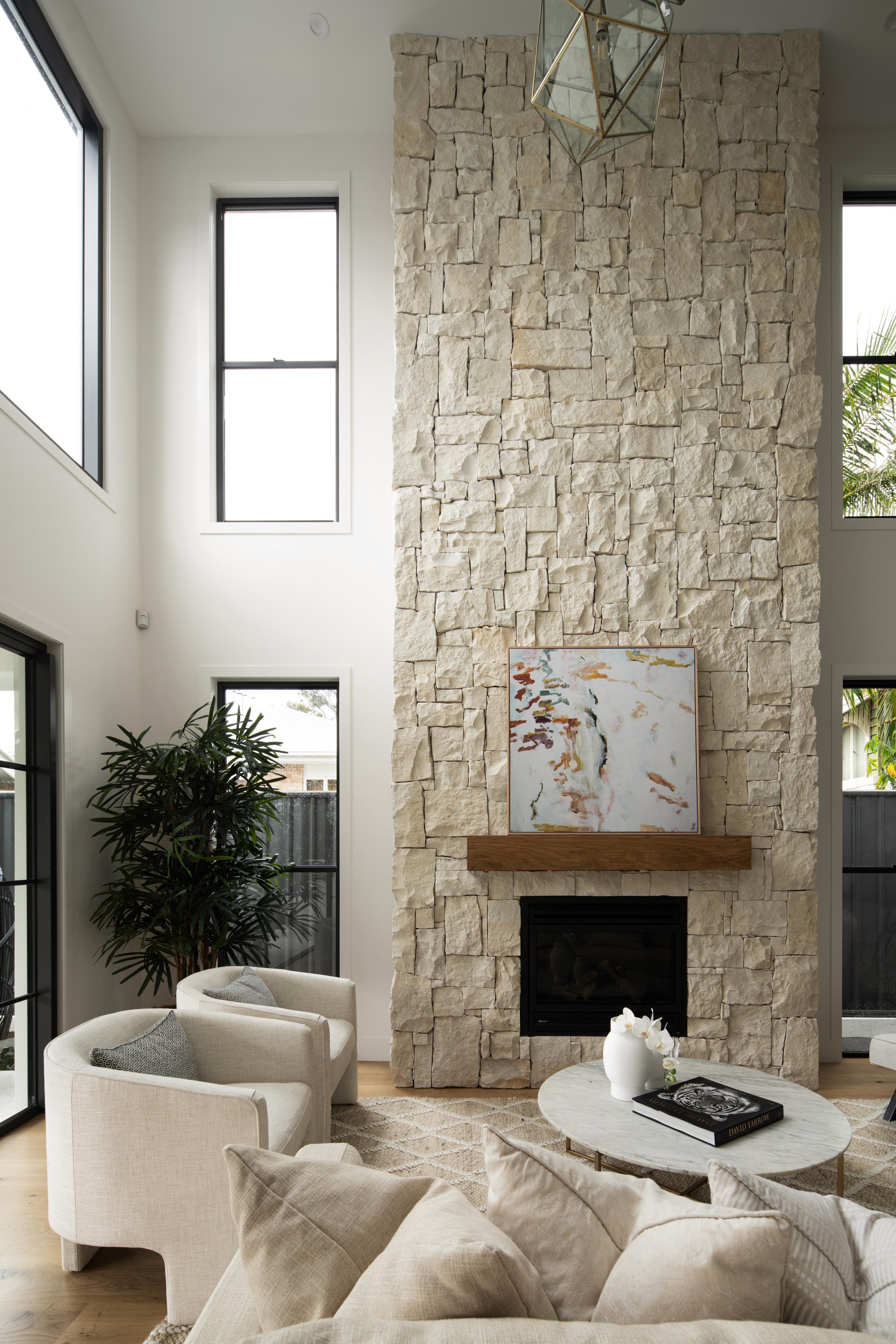 Double height living room with stacked stone fireplace