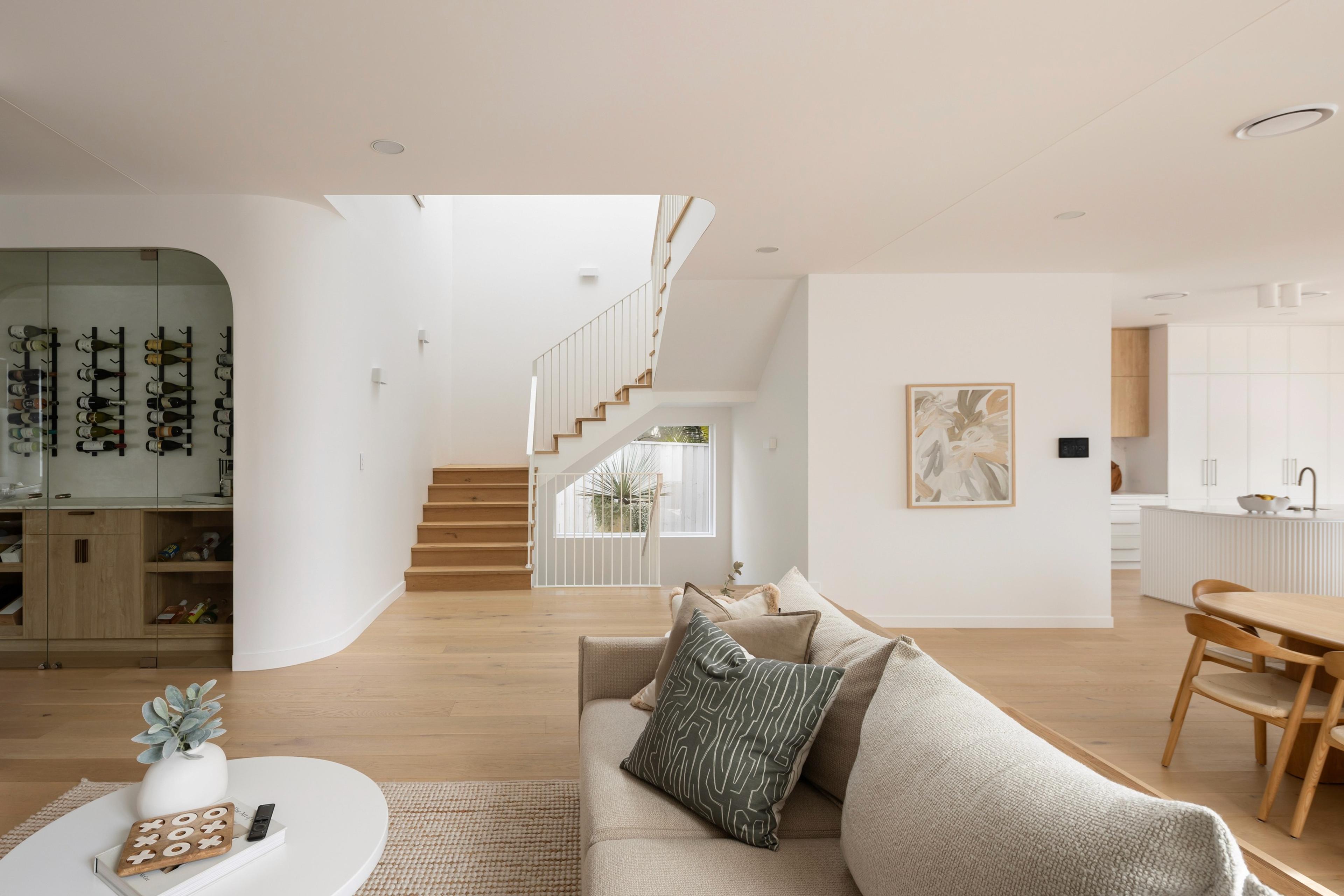 Living room with timber staircase and glass wine cellar
