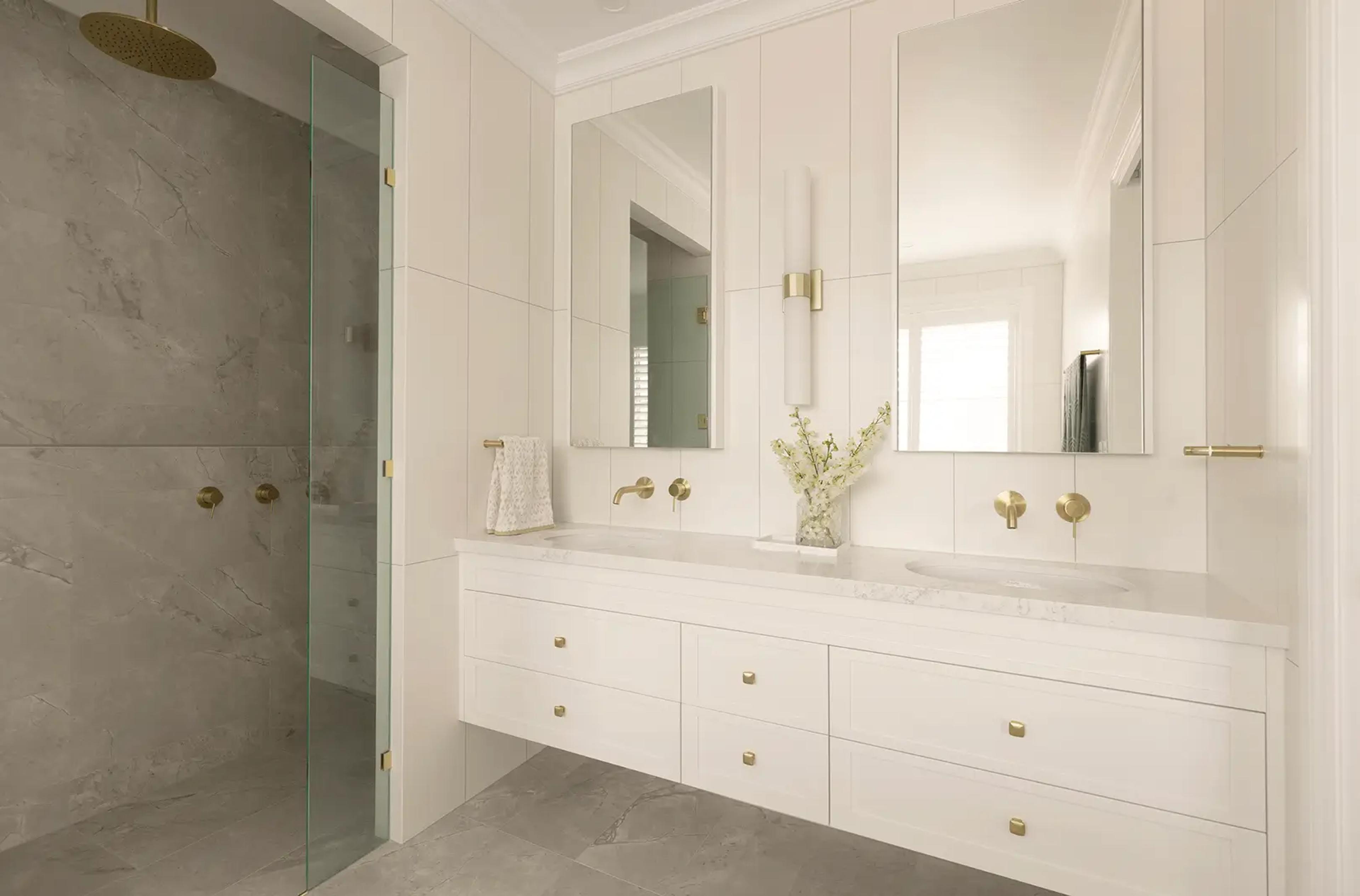 Bathroom with double vanity and stone tiled shower