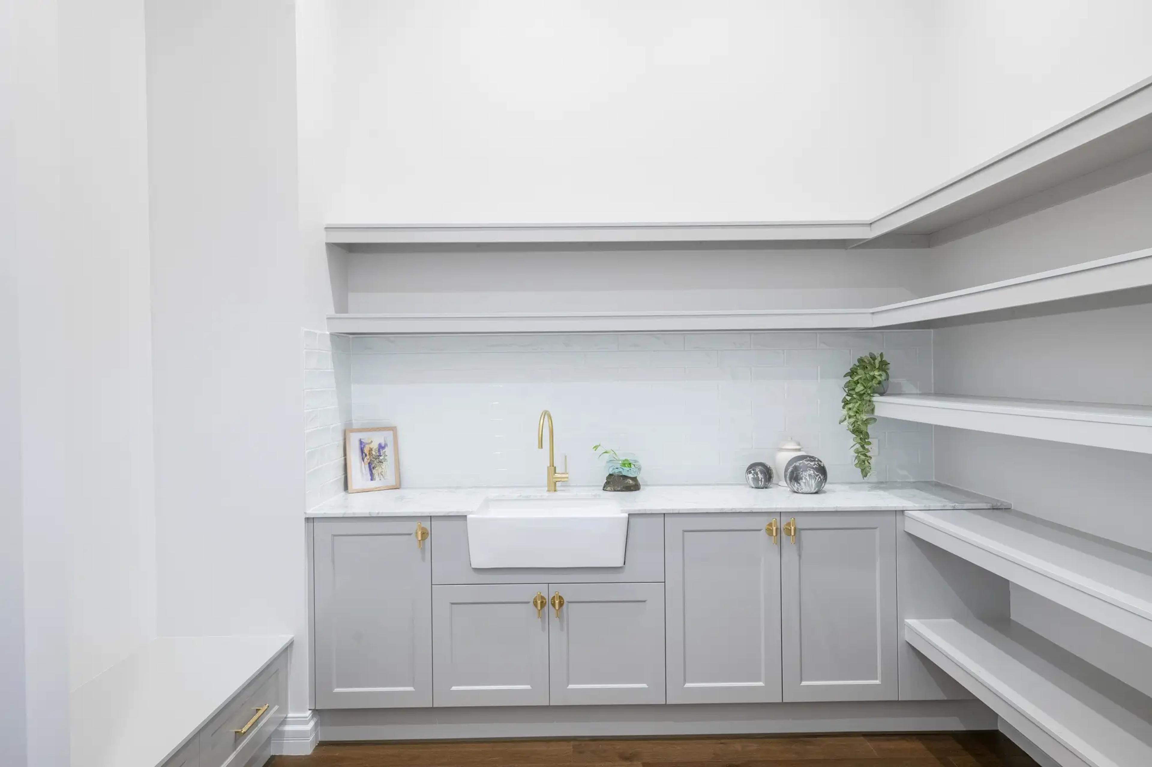 Butlers pantry with grey cabinetry and brass tapware