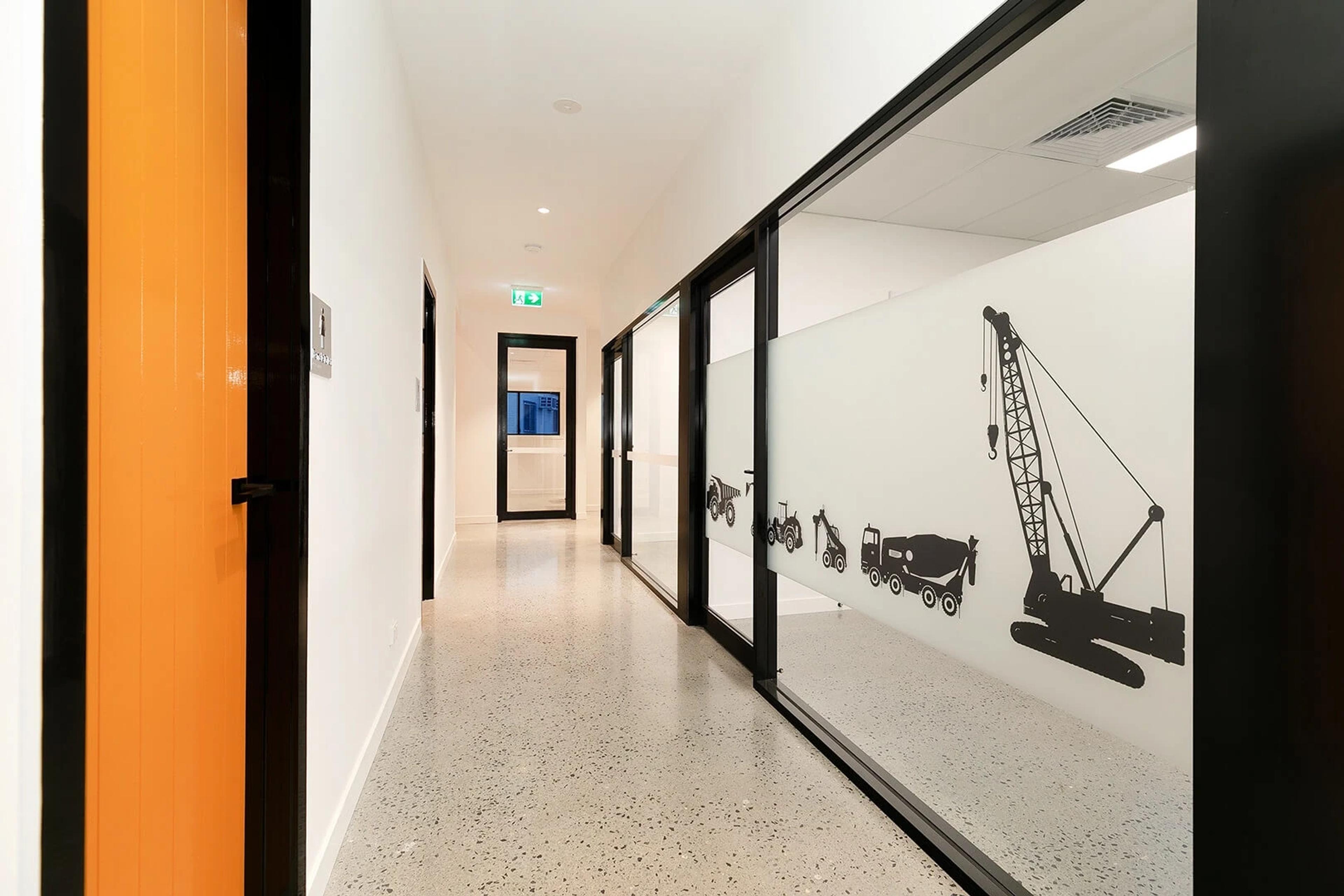 Hallway with crane and machinery graphics on glass partition
