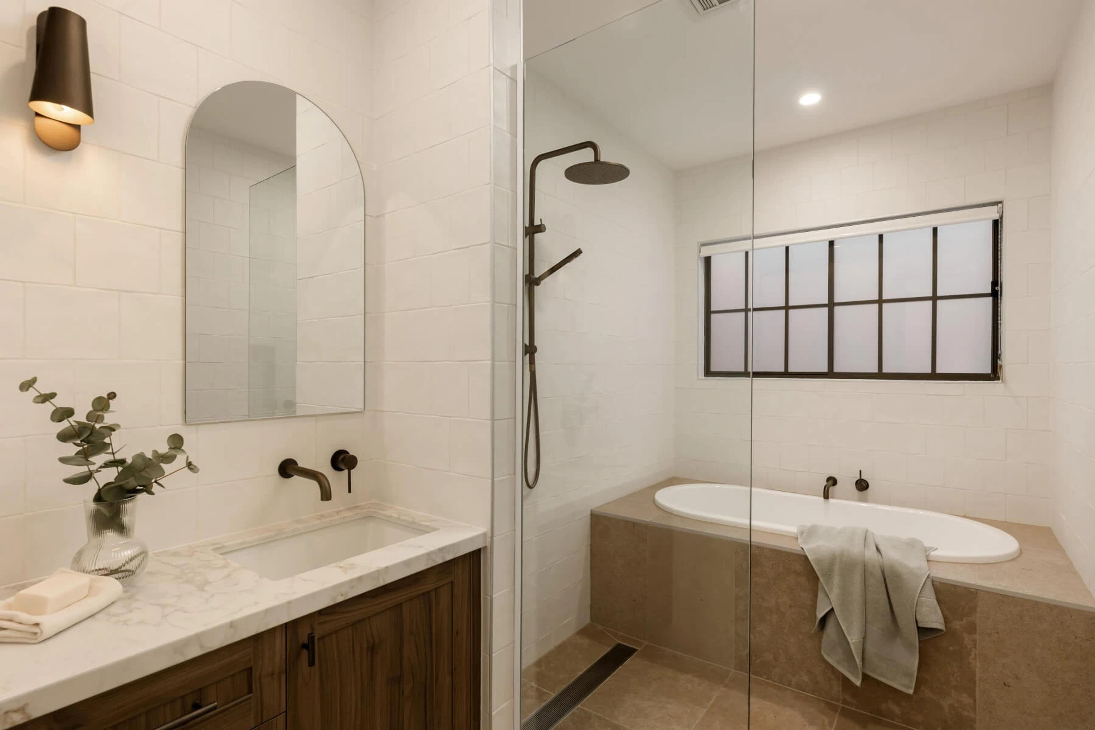 Ensuite with walk in shower, arched mirror and inset bath