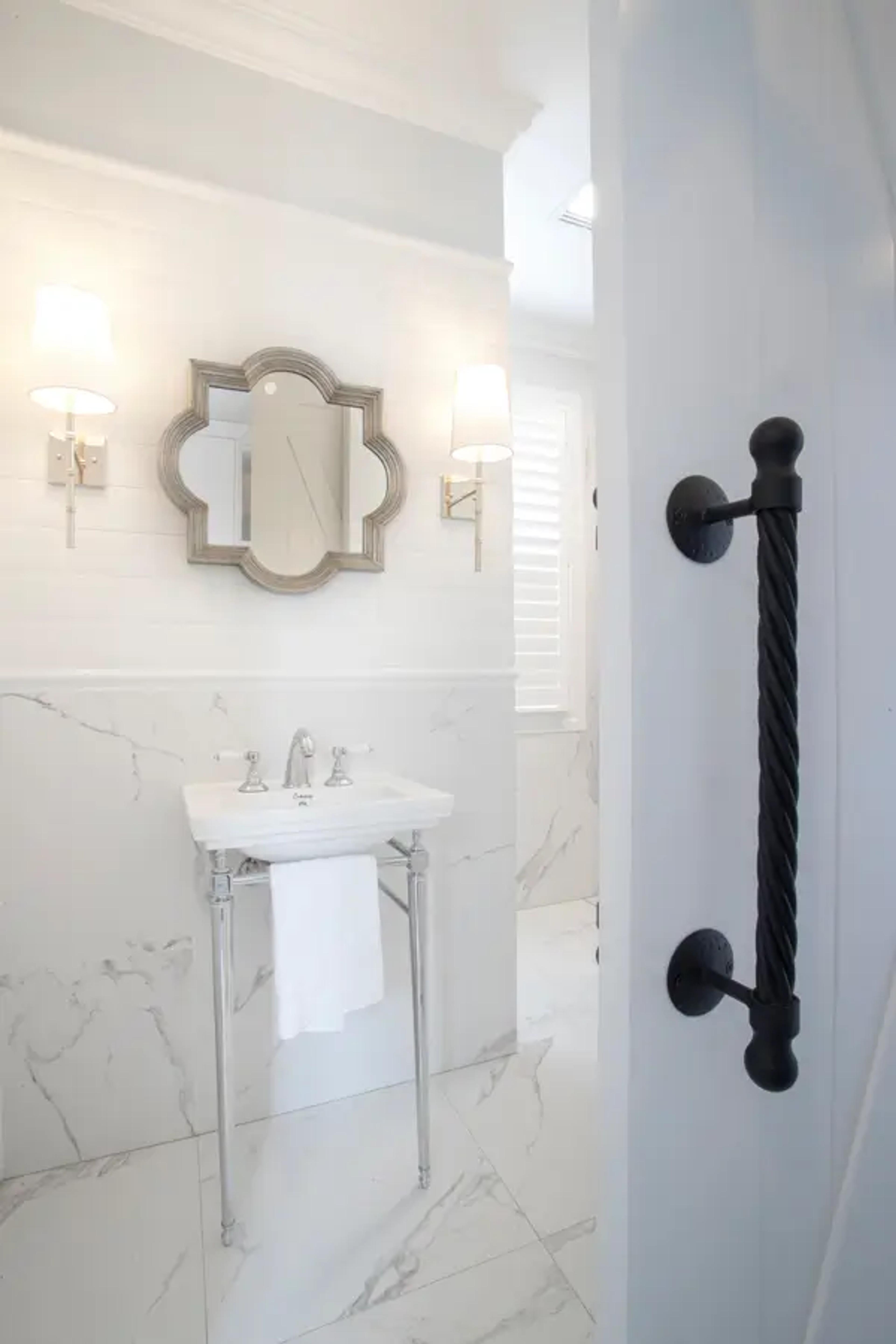 Powder room with pedestal basin and framed mirror