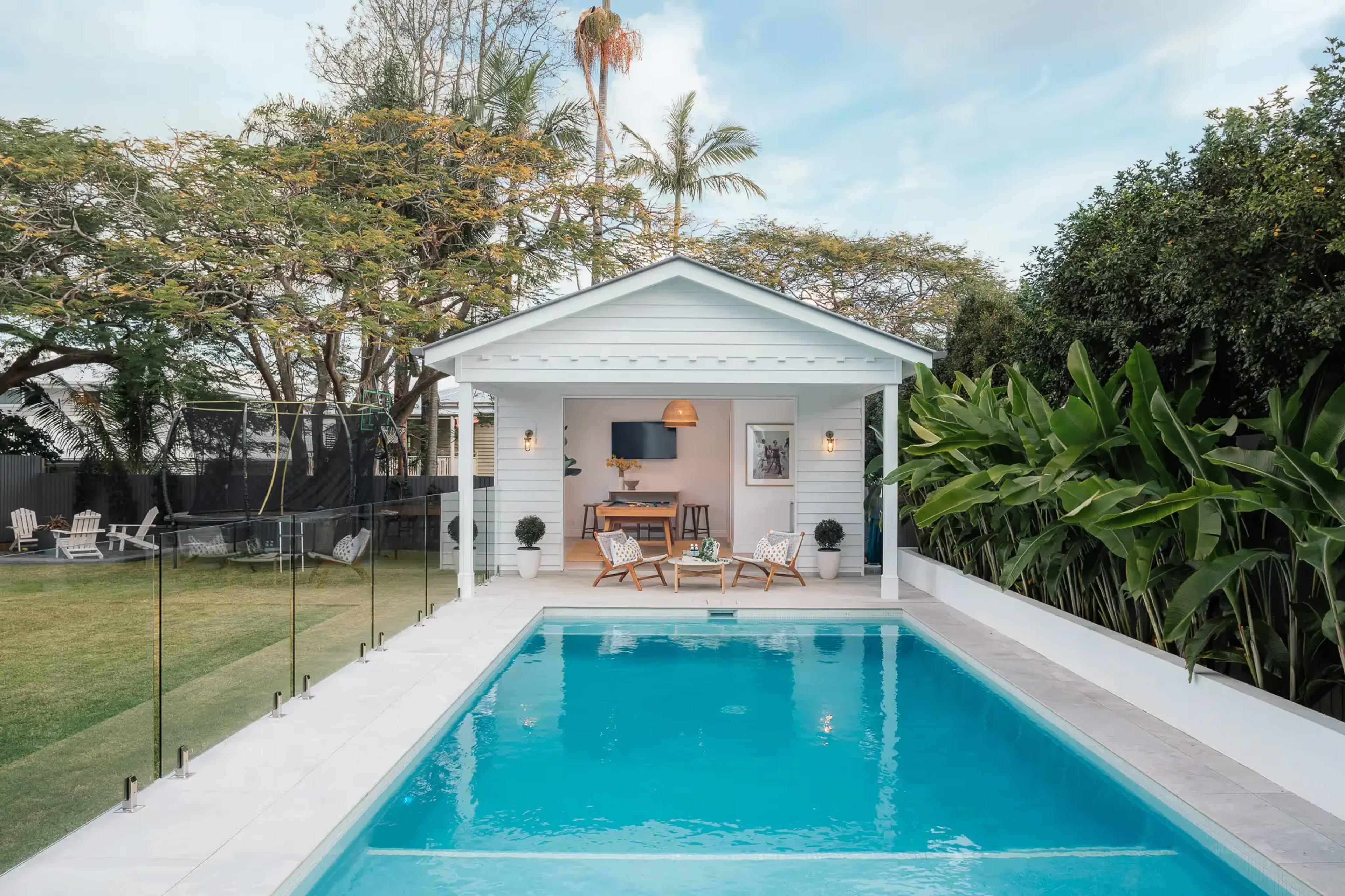 Suburban backyard oasis featuring a swimming pool and custom pool house in Brisbane