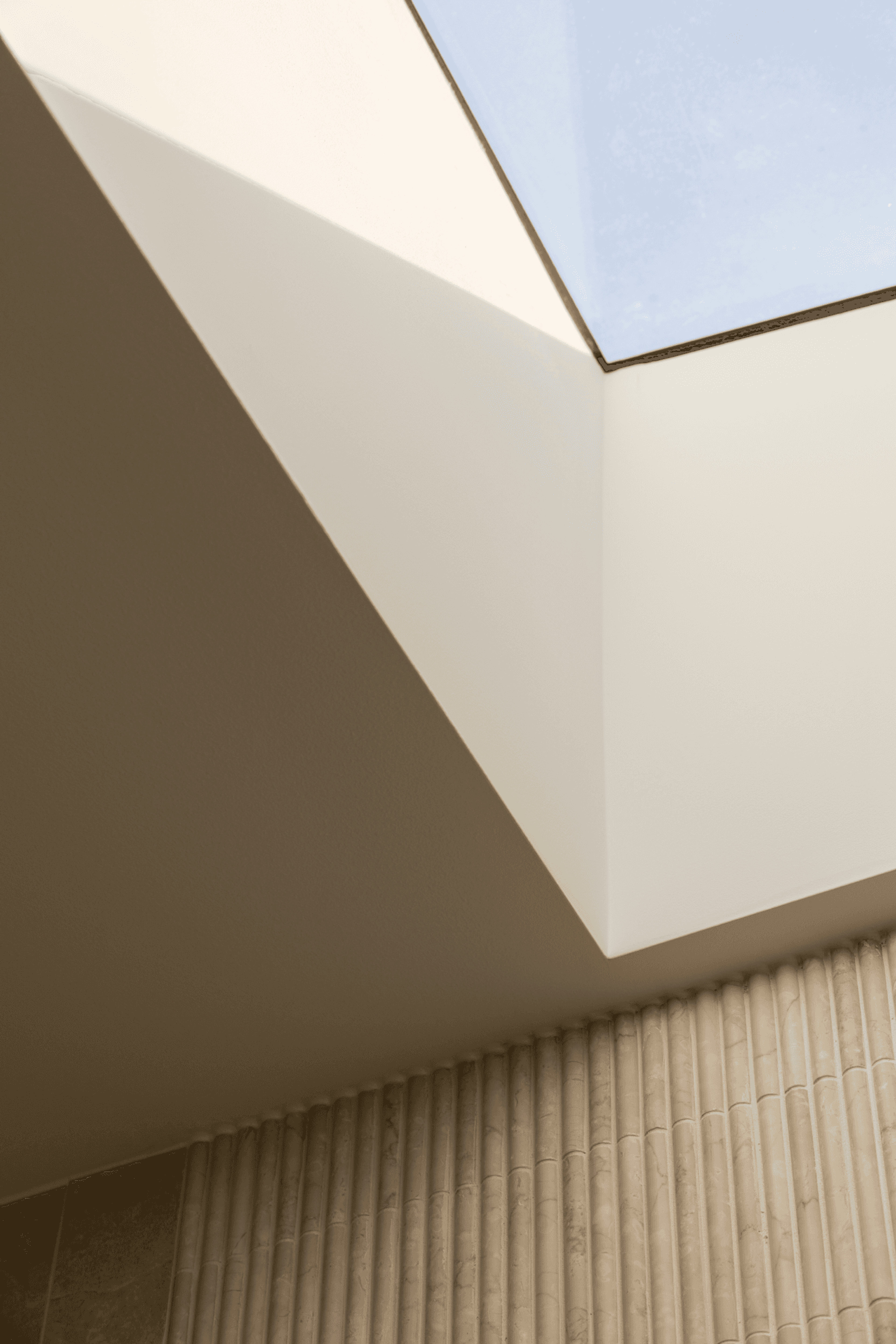 Interior skylight with angled walls and fluted stone