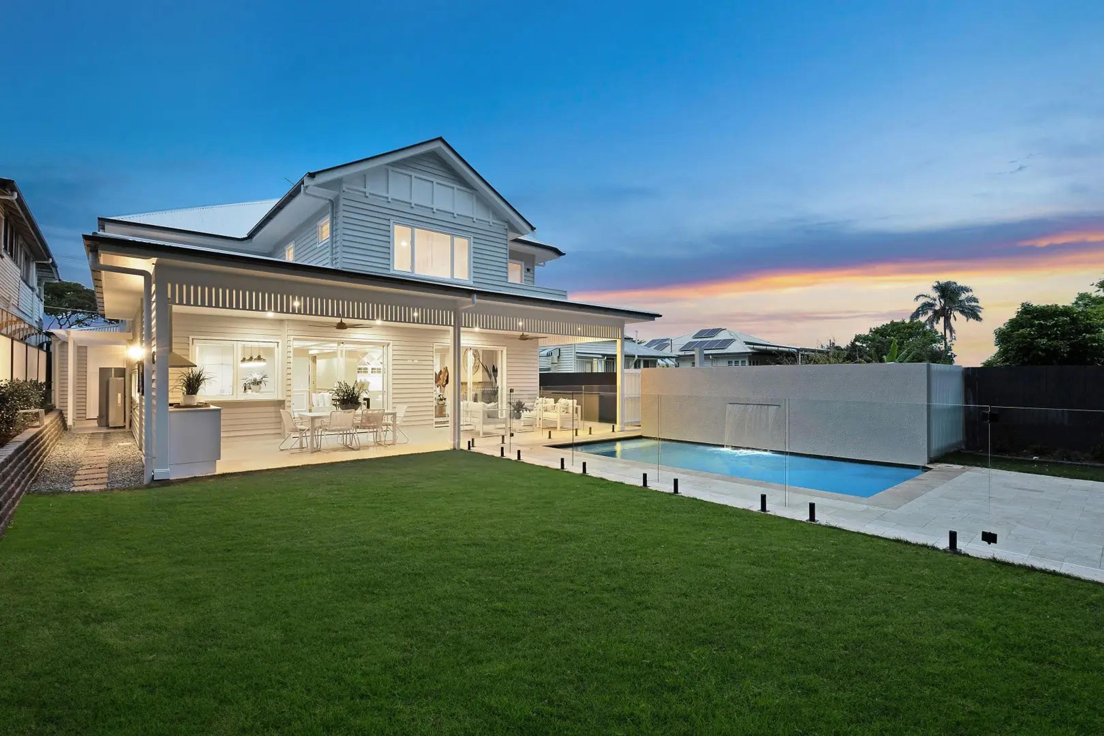 Rear exterior at dusk with covered patio and pool