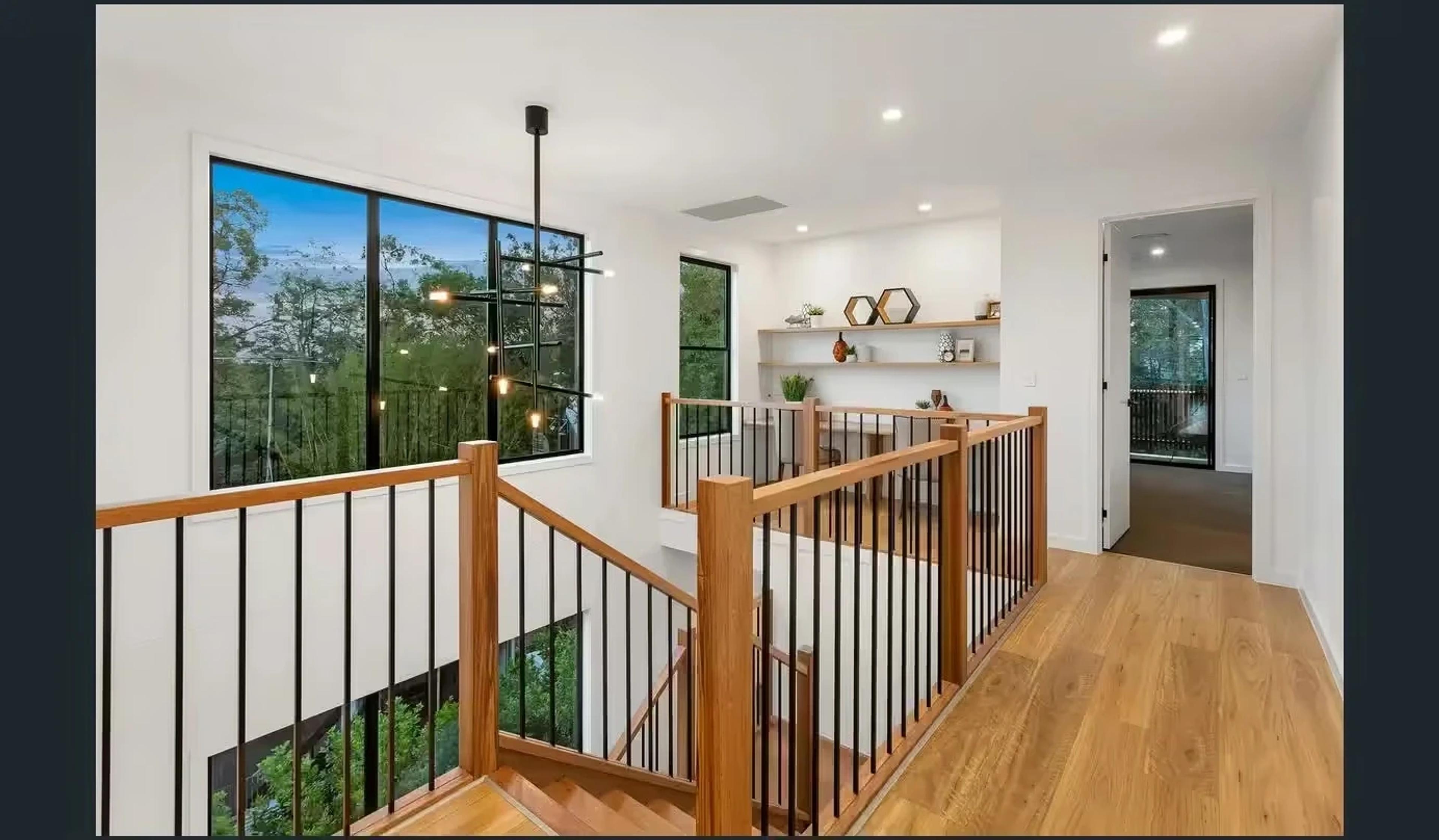 Upstairs landing with timber balustrade and treetop views